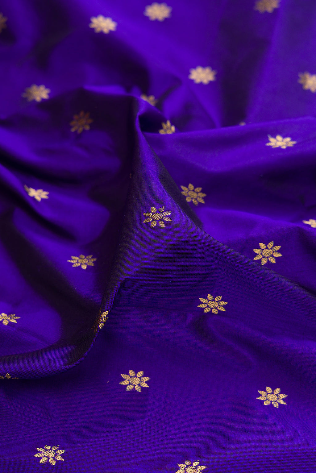 Close up of Royal Blue Paithani Silk Saree with Zari Butta on the body and Zari Border.  displaying folds