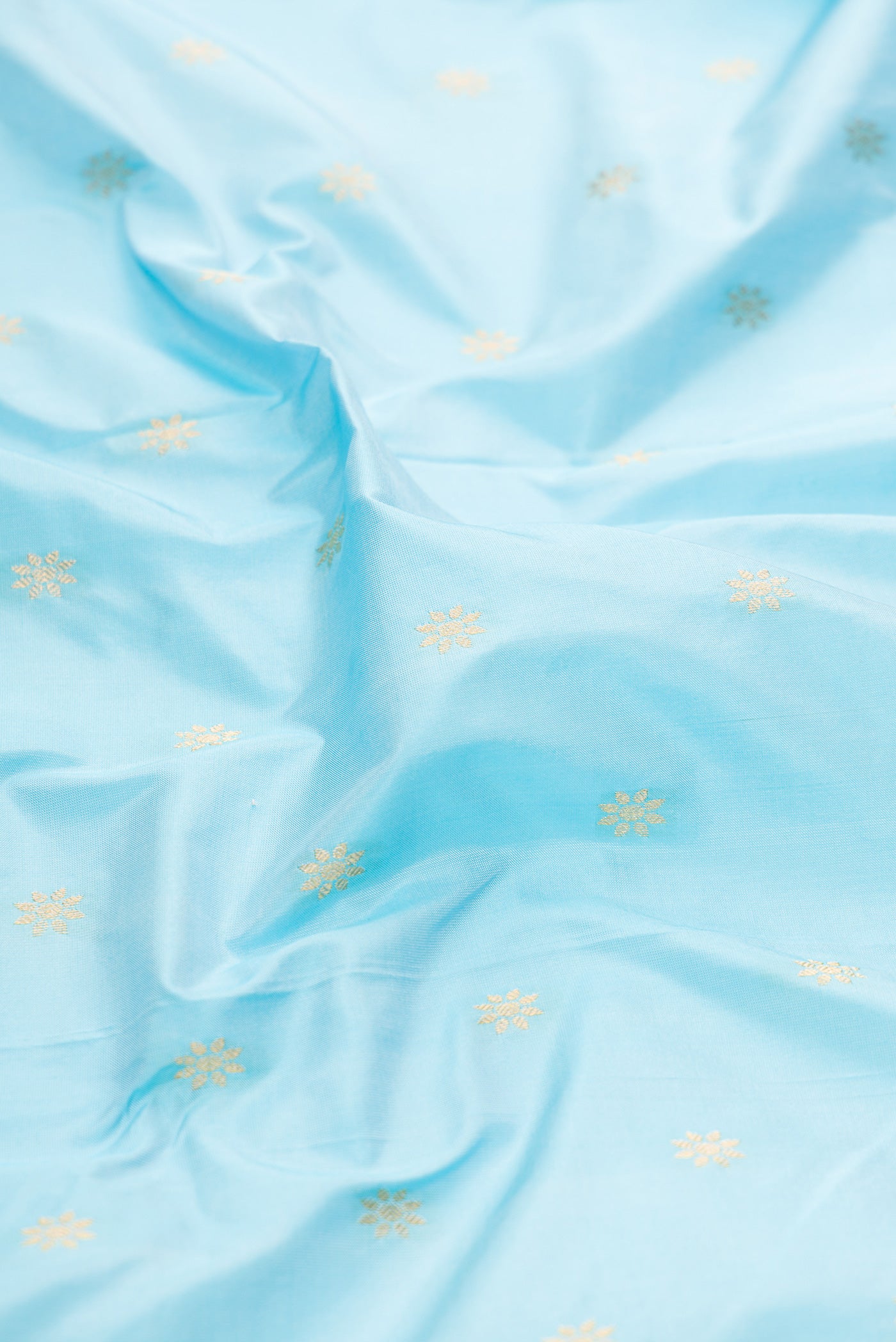 Close up of Sky Blue Paithani Silk Saree with Zari Butta on the body and Zari Border.  displaying folds