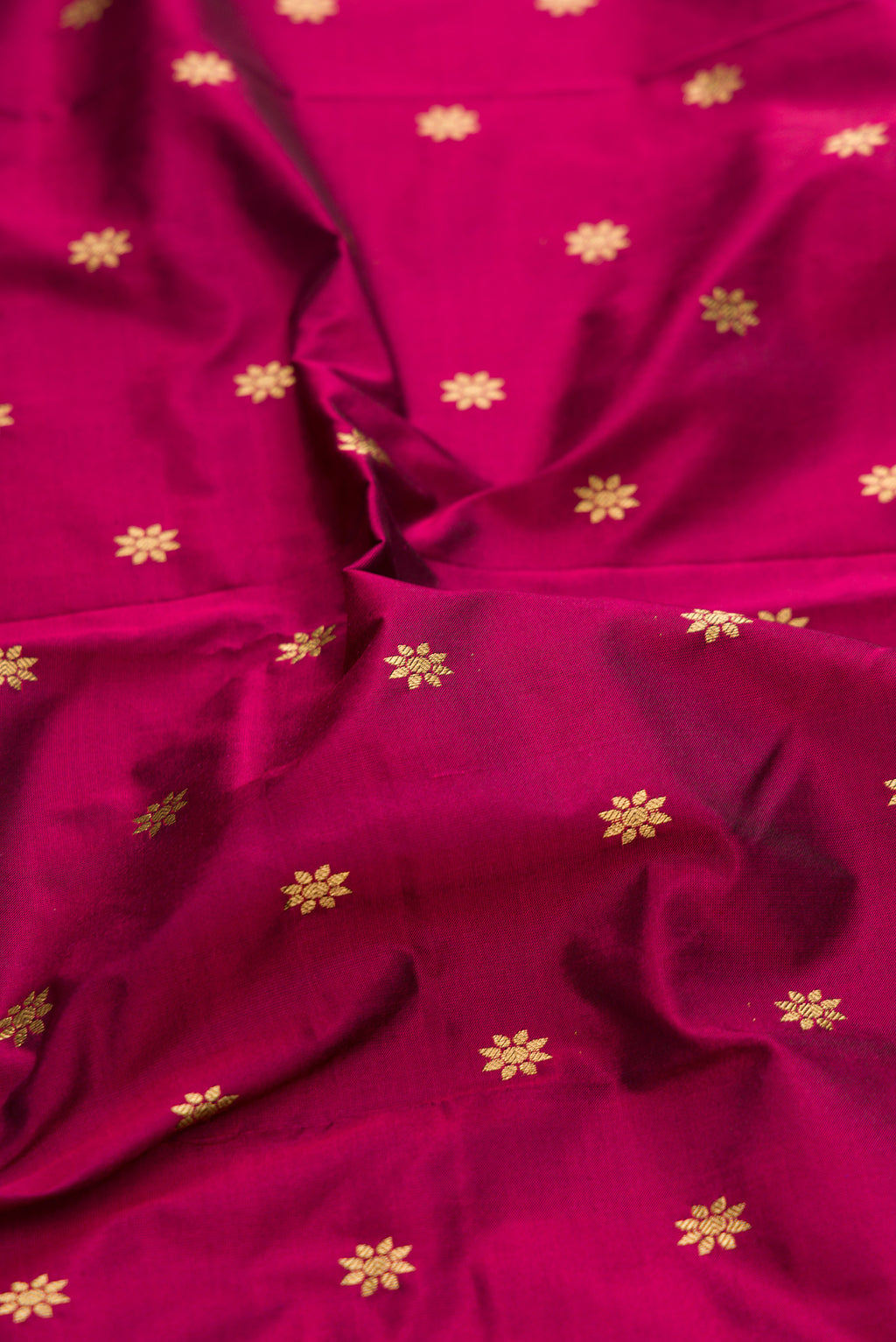 Close up of Magenta Paithani Silk Saree with Zari Butta on the body and Zari Border.  displaying folds
