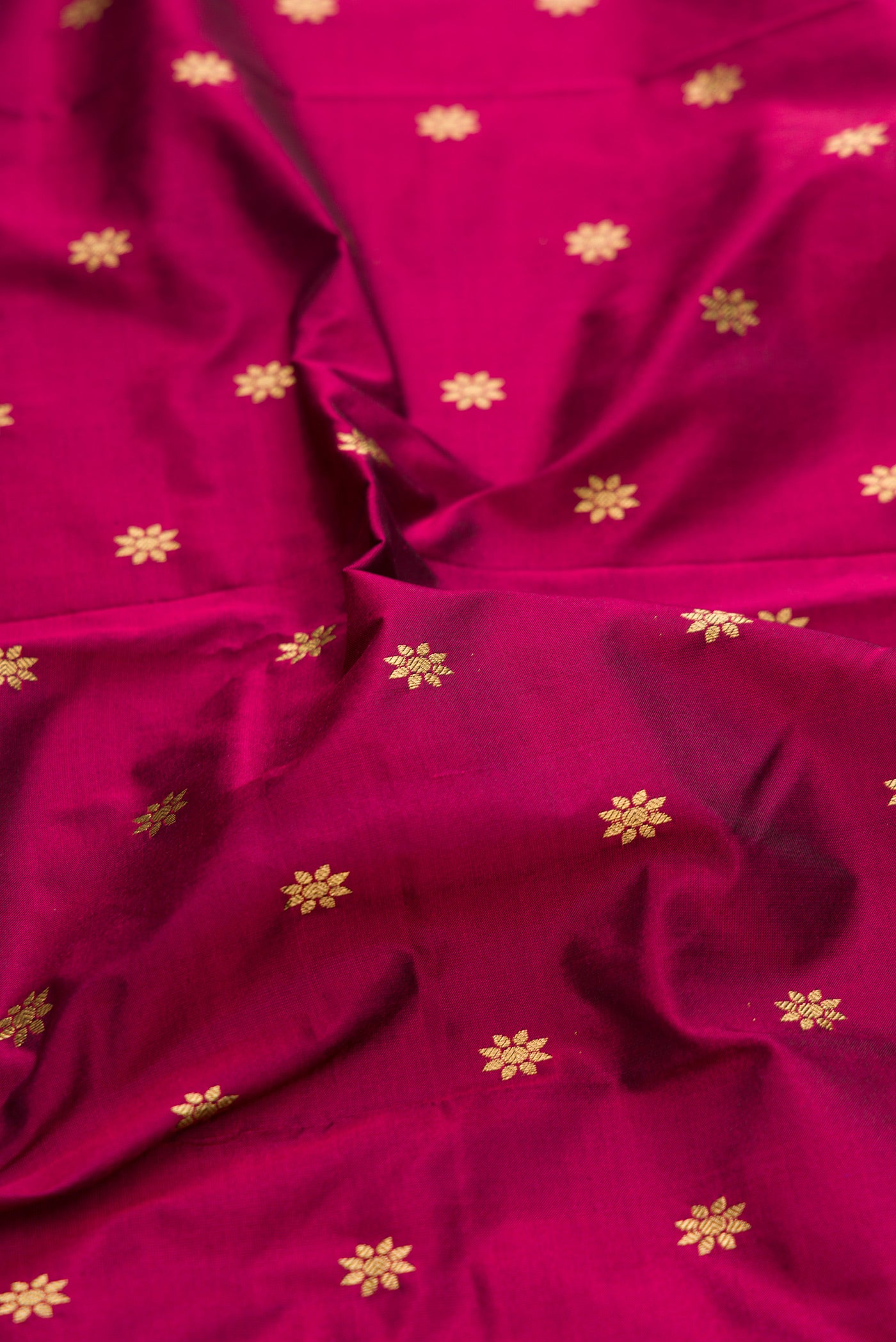 Close up of Magenta Paithani Silk Saree with Zari Butta on the body and Zari Border.  displaying folds