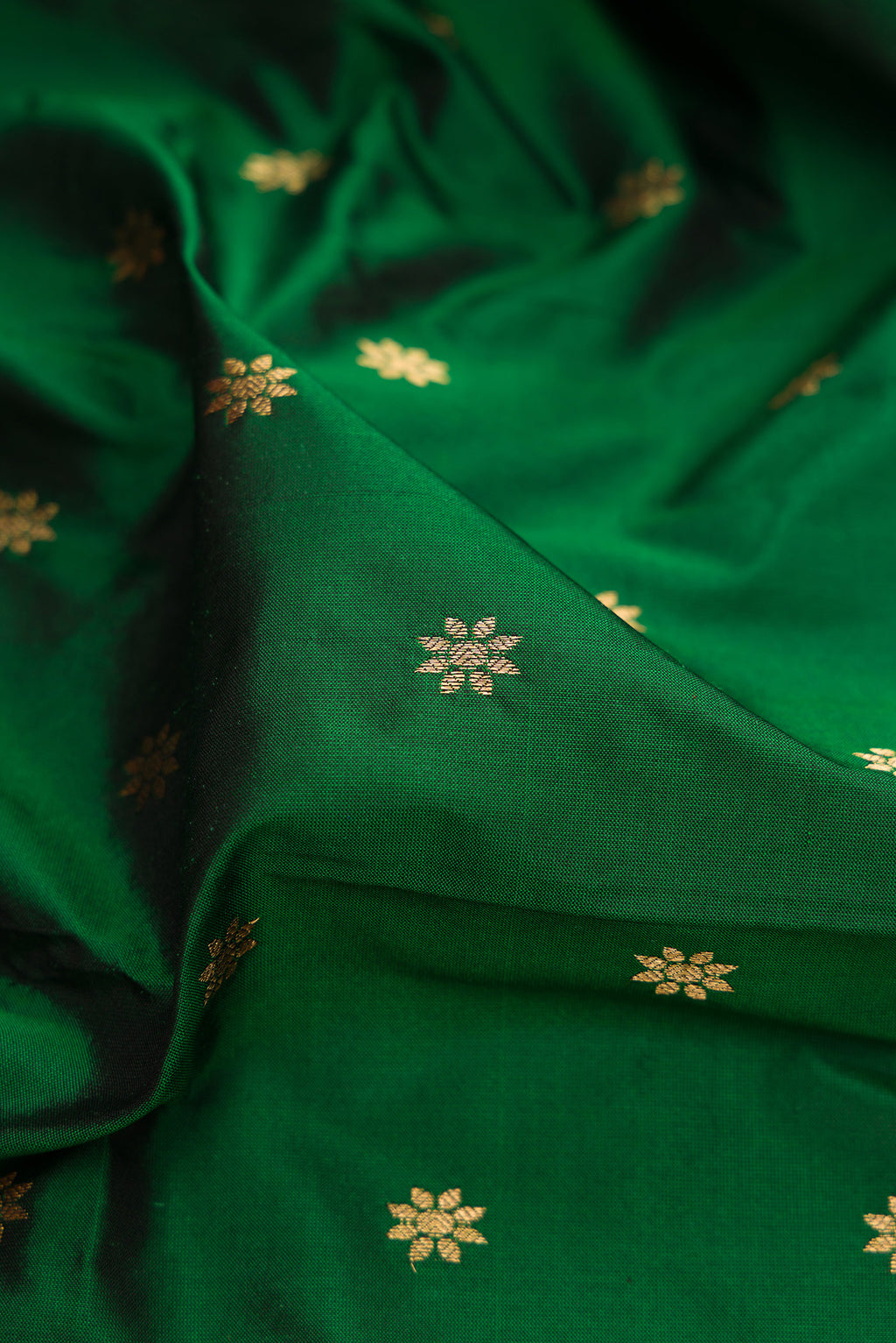 Close up of Bottle Green Paithani Silk Saree with Zari Butta on the body and Zari Border.  displaying folds