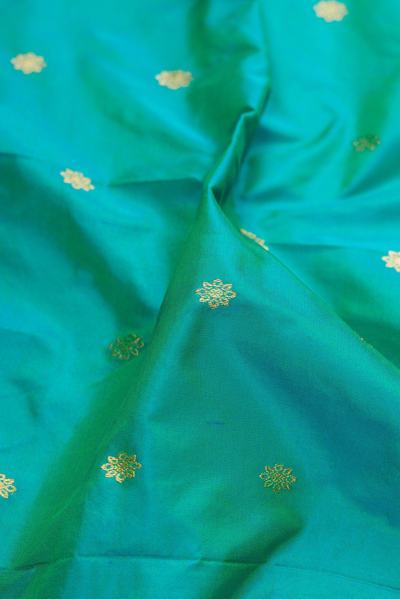 Close up of Sea Green Paithani Silk Saree with Zari Butta on the body and Zari Border.  displaying folds