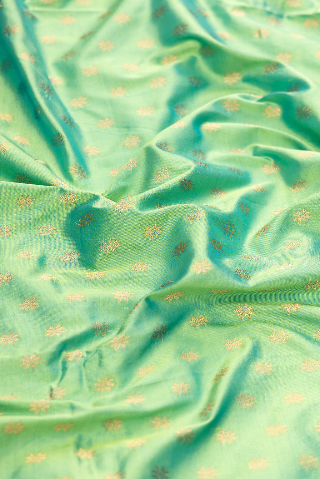 Close up of Sea Green Dual Tone Paithani Silk Saree with Zari Butta on the body and Zari Border.  displaying folds