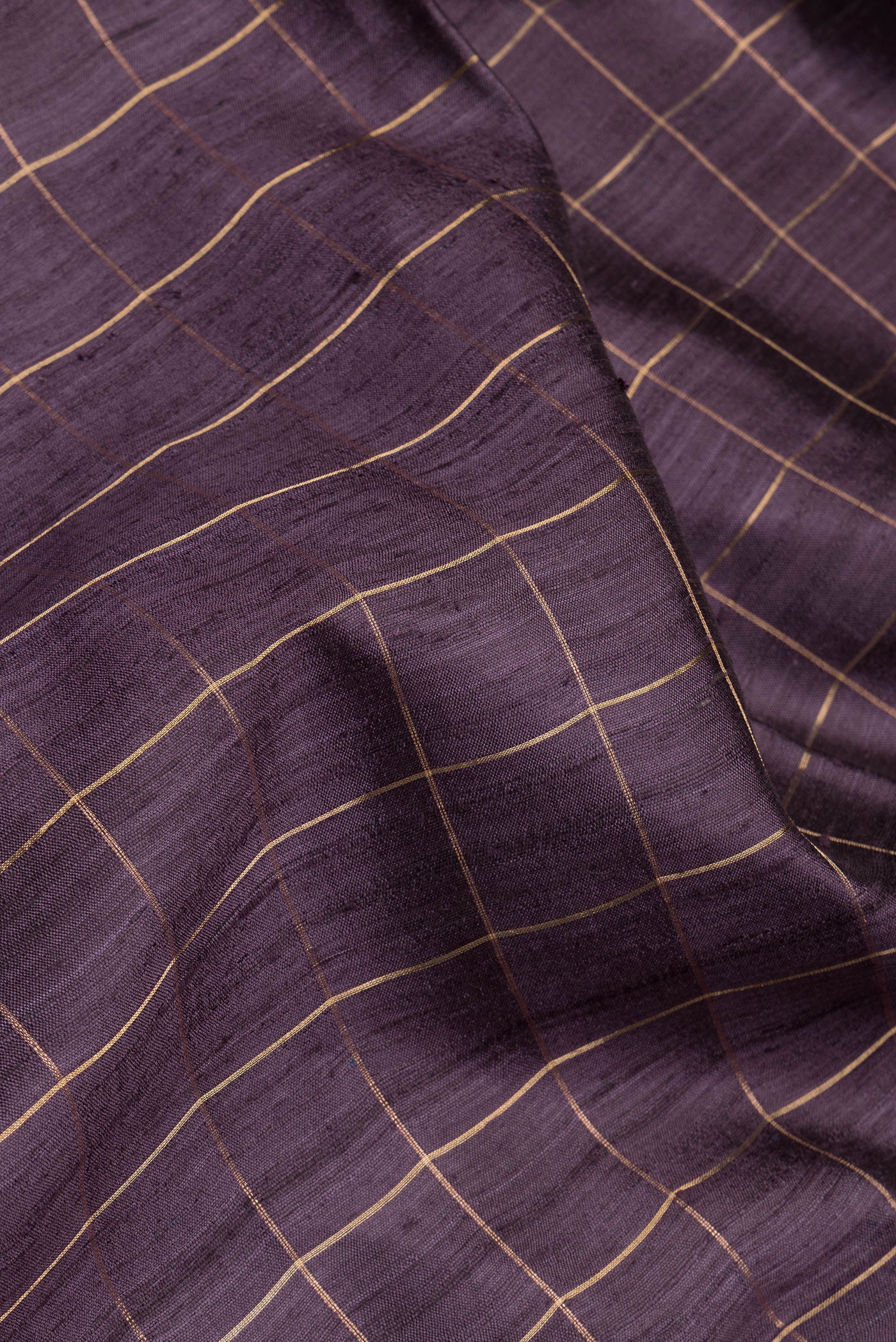 Close up of Burgundy Tussar Silk Saree with Checked design on the body and Zari Border.  displaying folds