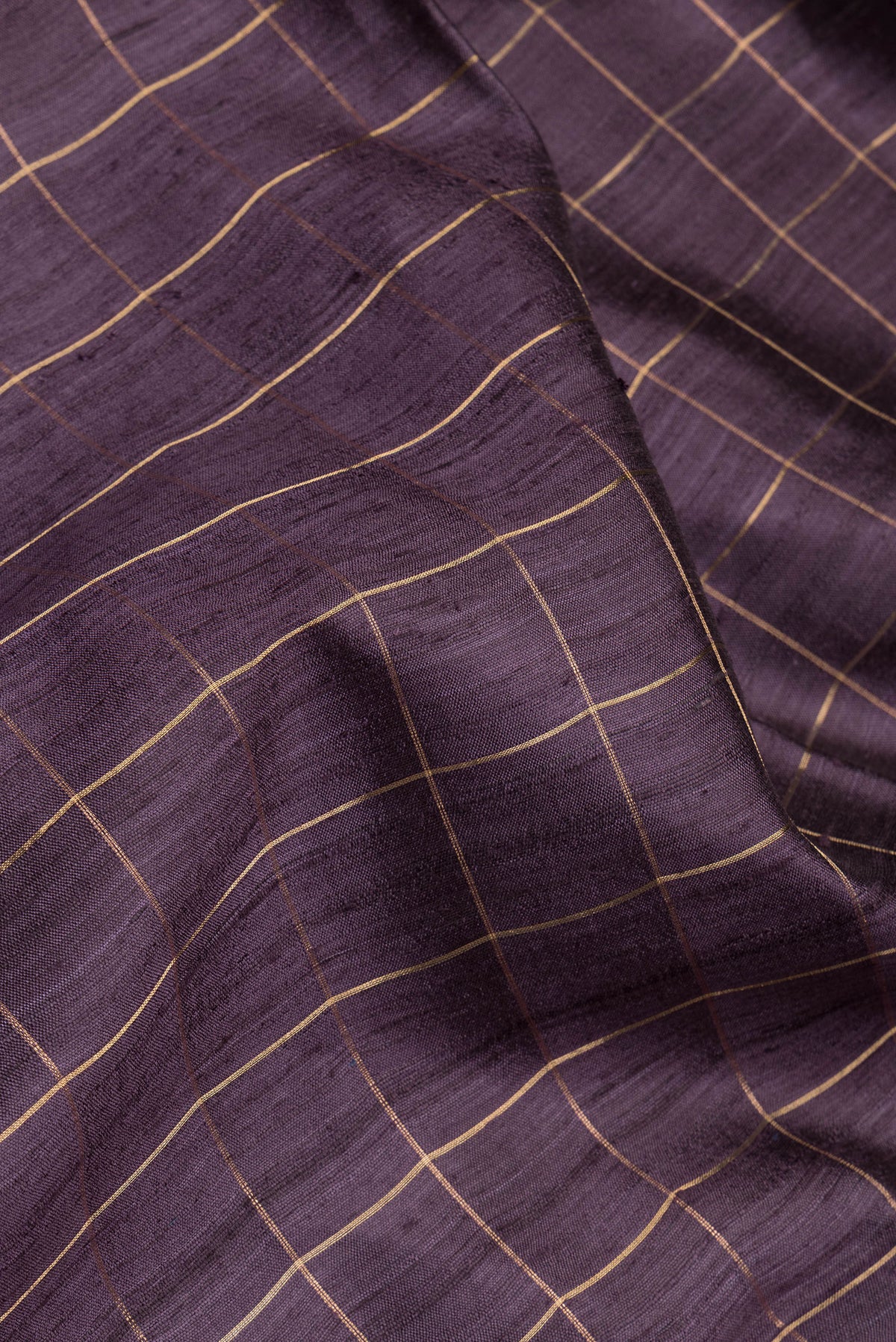 Close up of Burgundy Tussar Silk Saree with Checked design on the body and Zari Border.  displaying folds