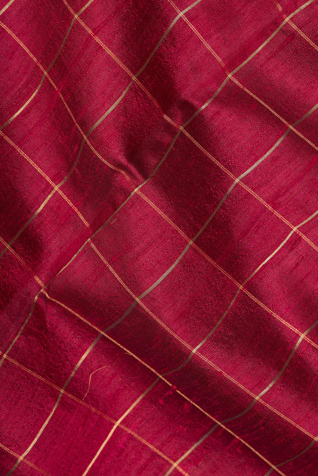 Close up of Maroon Tussar Saree with Checked design on the body and Zari Border.  displaying folds