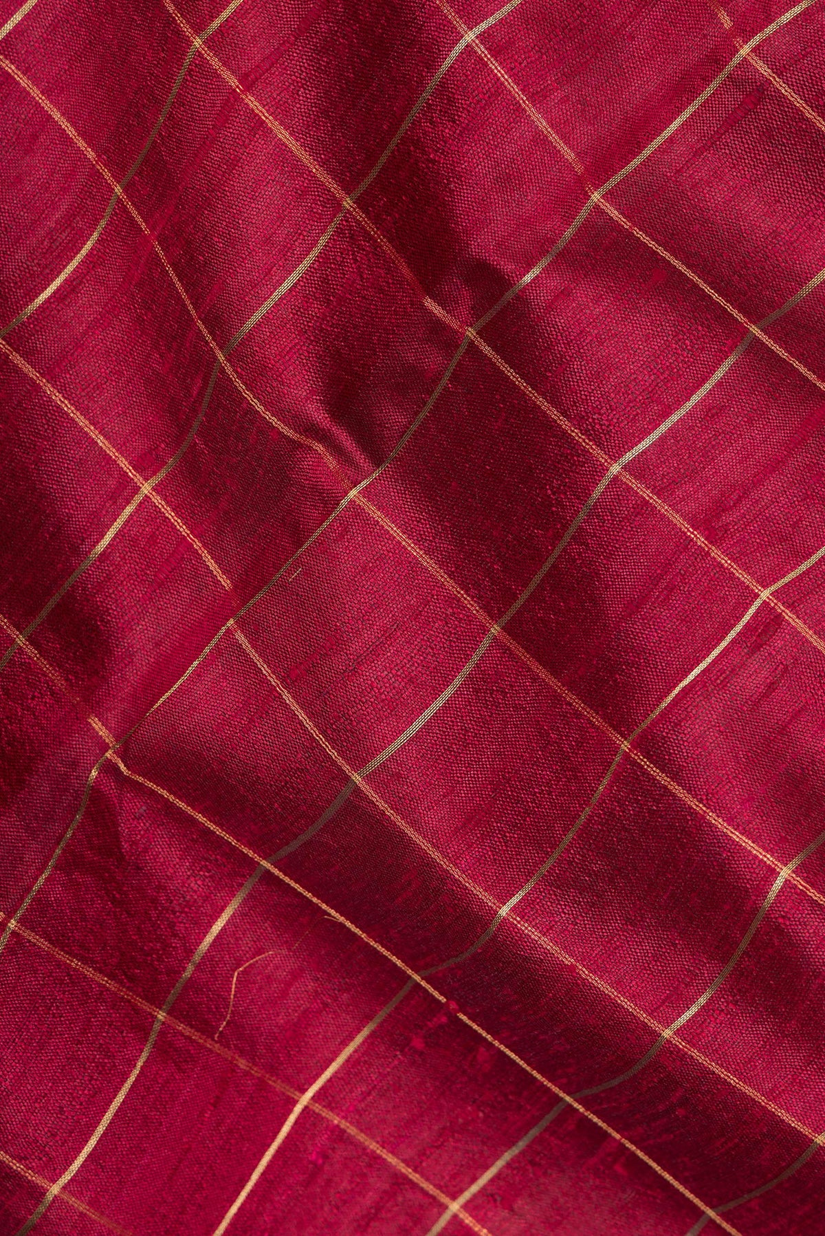 Close up of Maroon Tussar Saree with Checked design on the body and Zari Border.  displaying folds
