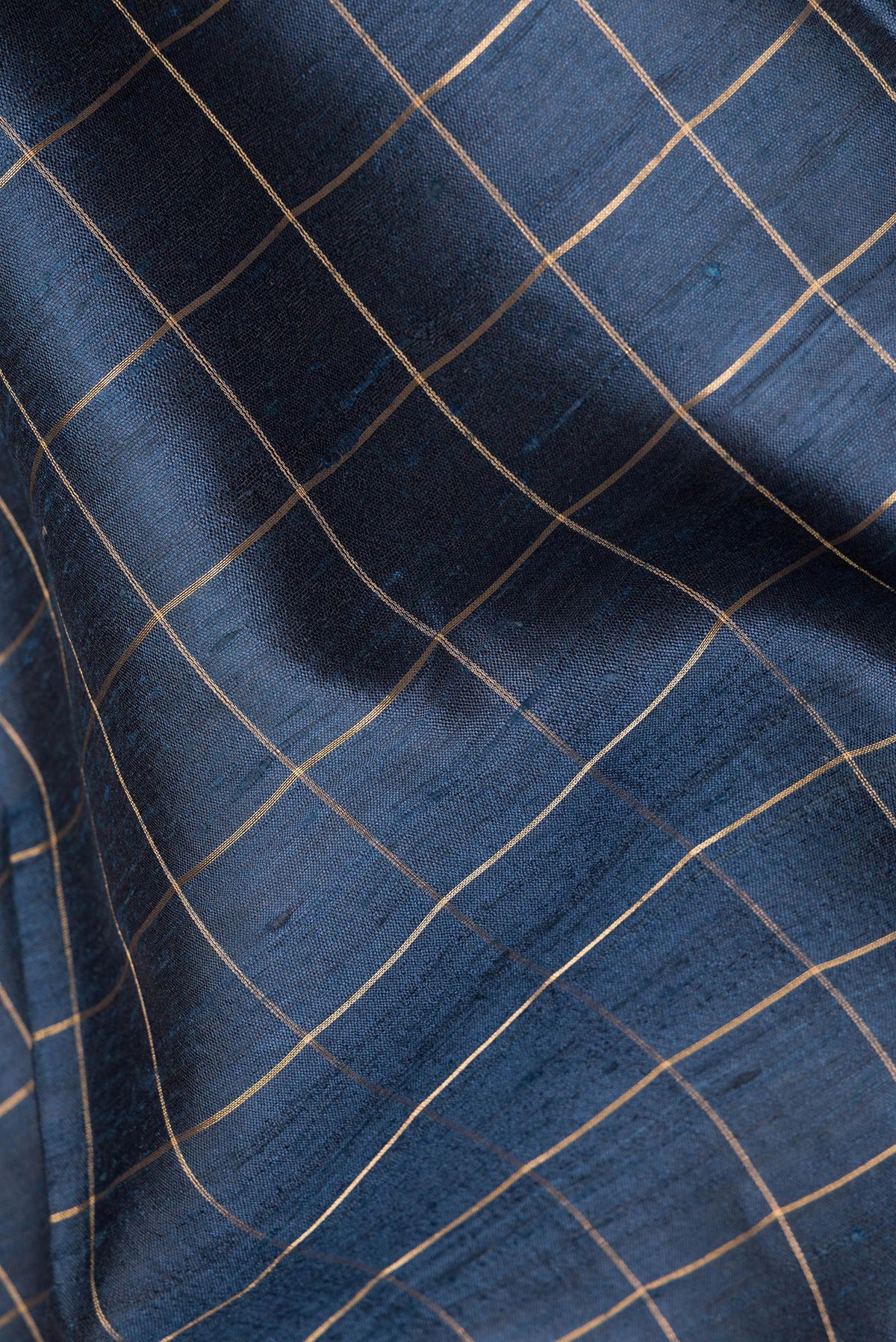 Close up of Blue Grey Tussar Saree with Checked design on the body and Zari Border.  displaying folds