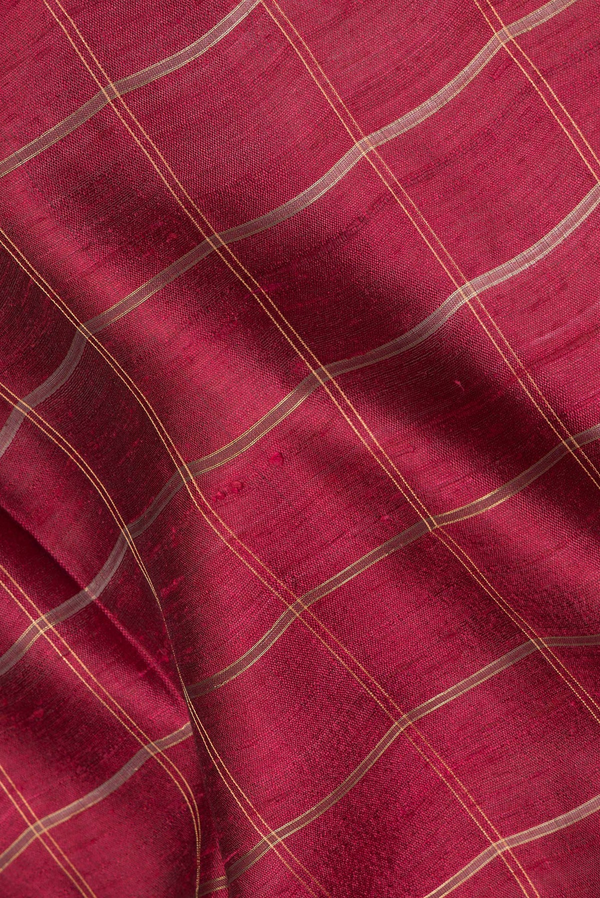 Close up of Maroon Tussar Saree with Checked design on the body and Zari Border.  displaying folds