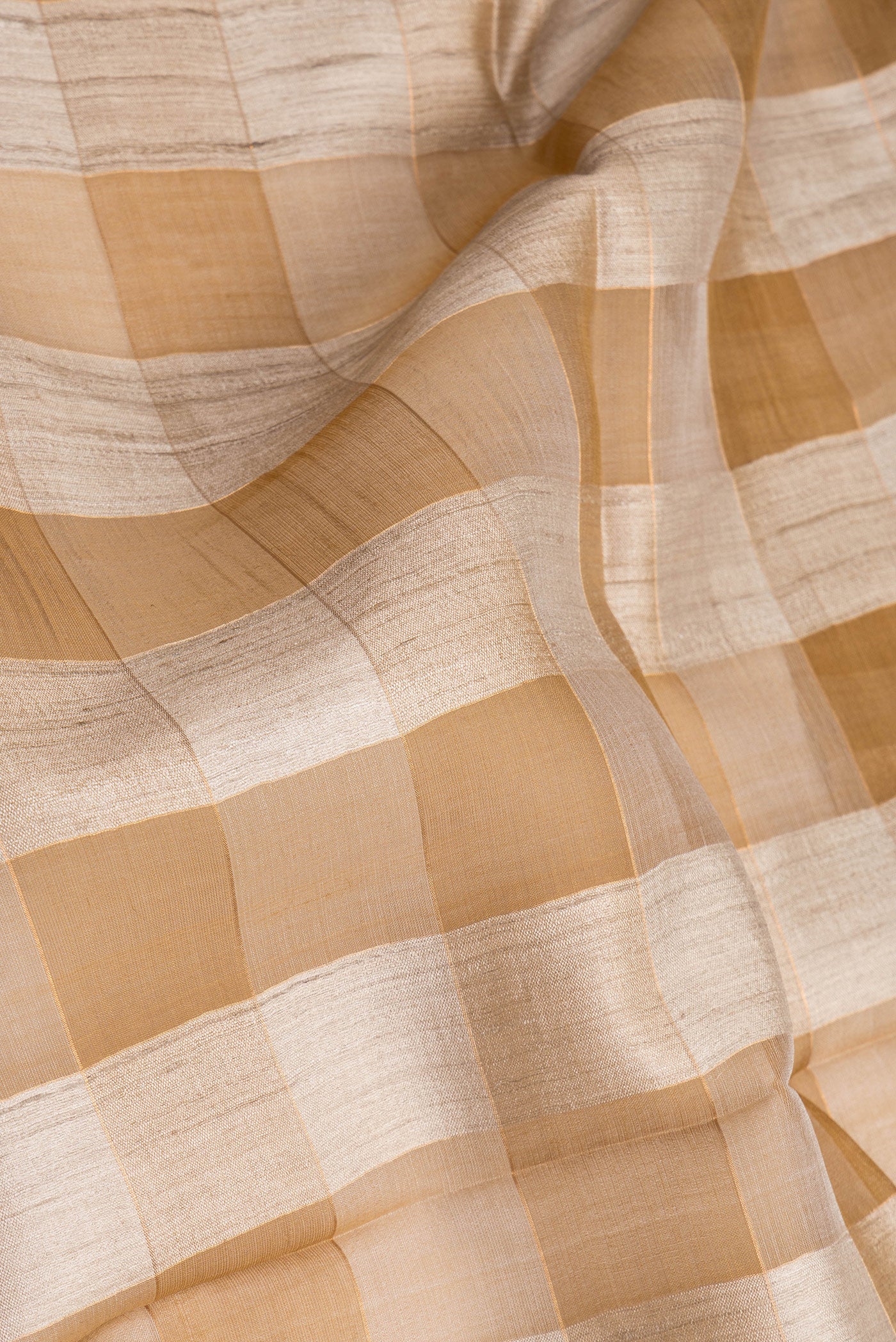 Close up of Multi Color Tussar Silk Saree with Checked design on the body and Zari Border.  displaying folds