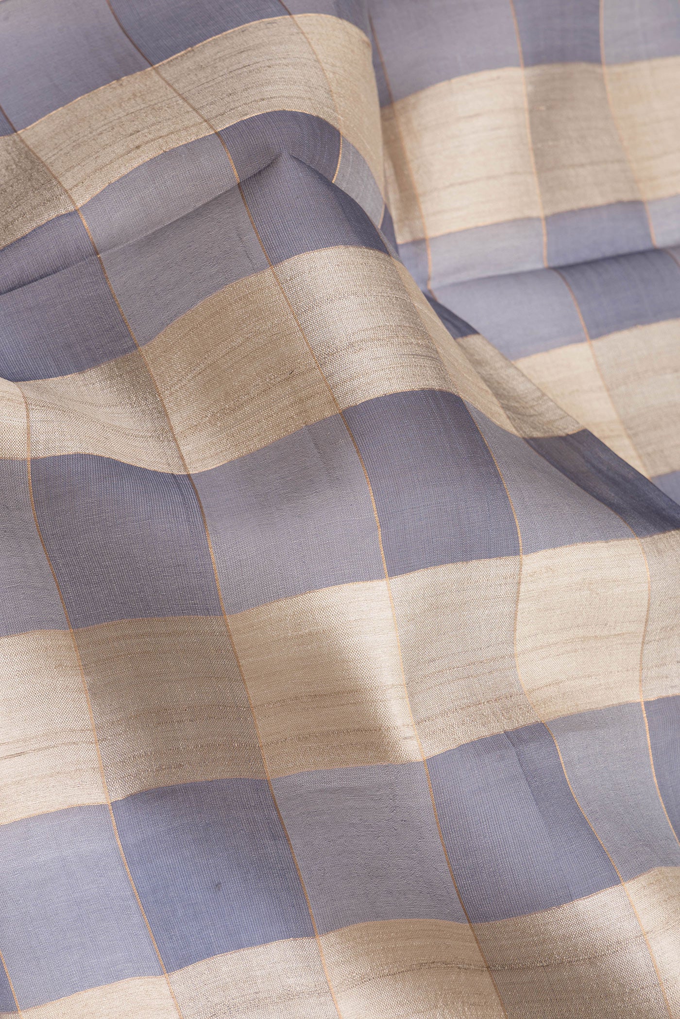 Close up of Multi Color Tussar Silk Saree with Checked design on the body and Zari Border.  displaying folds