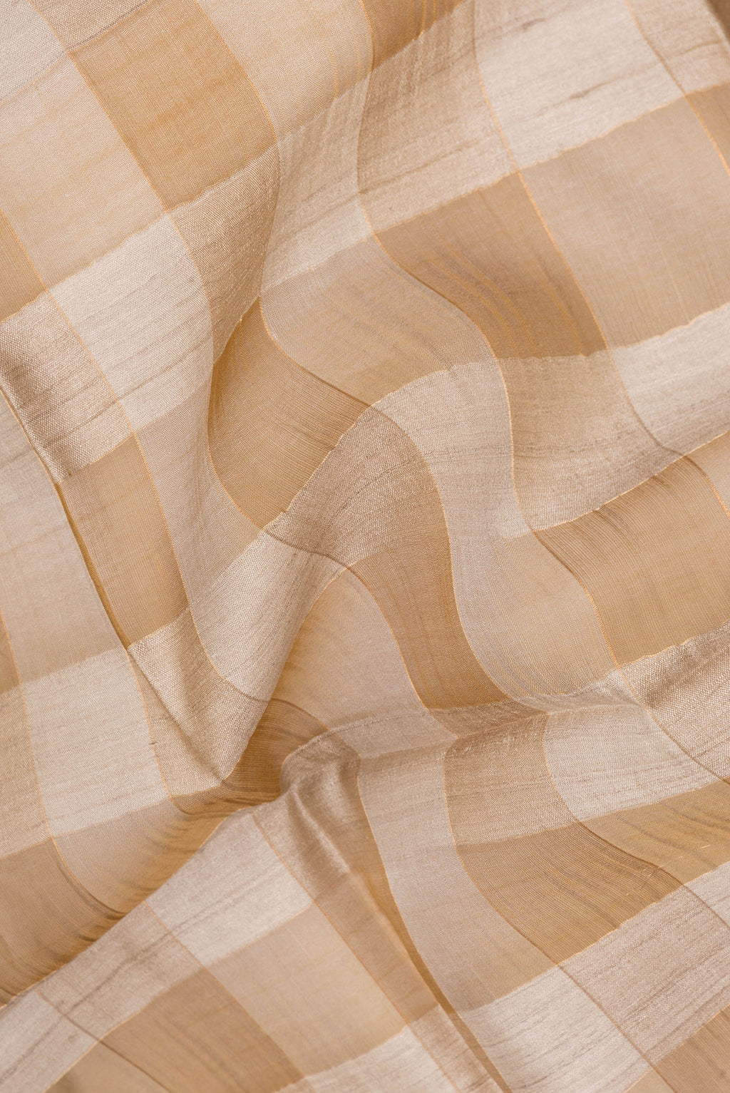 Close up of Gold and Brown Color Tussar Silk Saree with Checked design on the body and Zari Border.  displaying folds