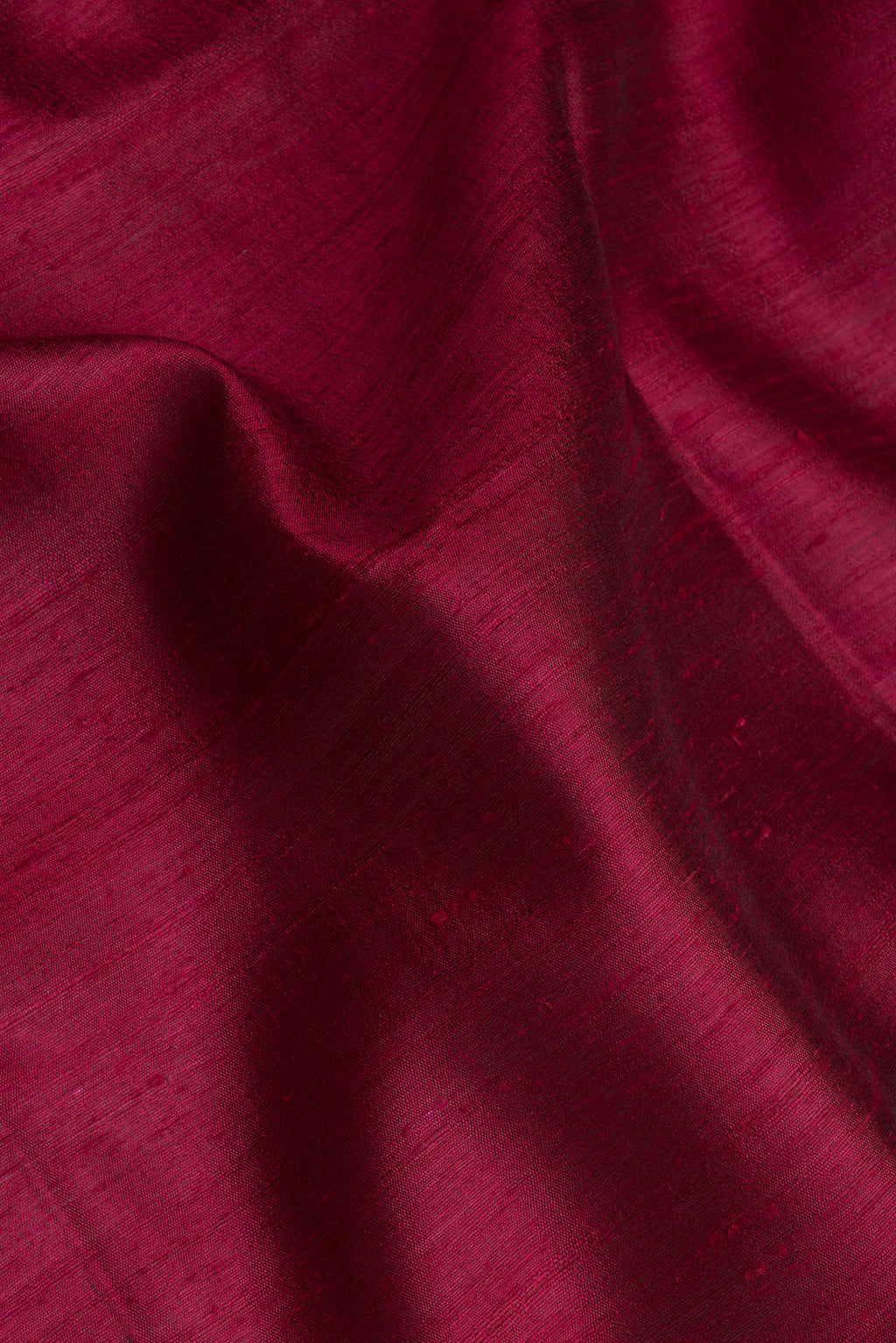 Close up of Maroon Tussar Silk Saree with Plain Body and Zari Border.  displaying folds