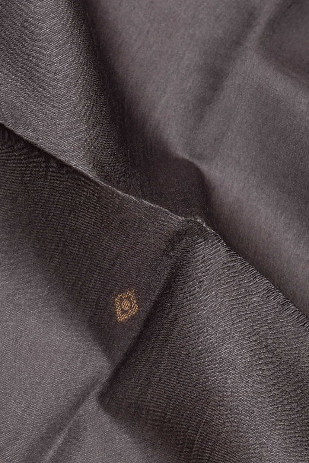 Close up of Grey Tussar Saree with Zari Butta on the body and Ikat Border.  displaying folds