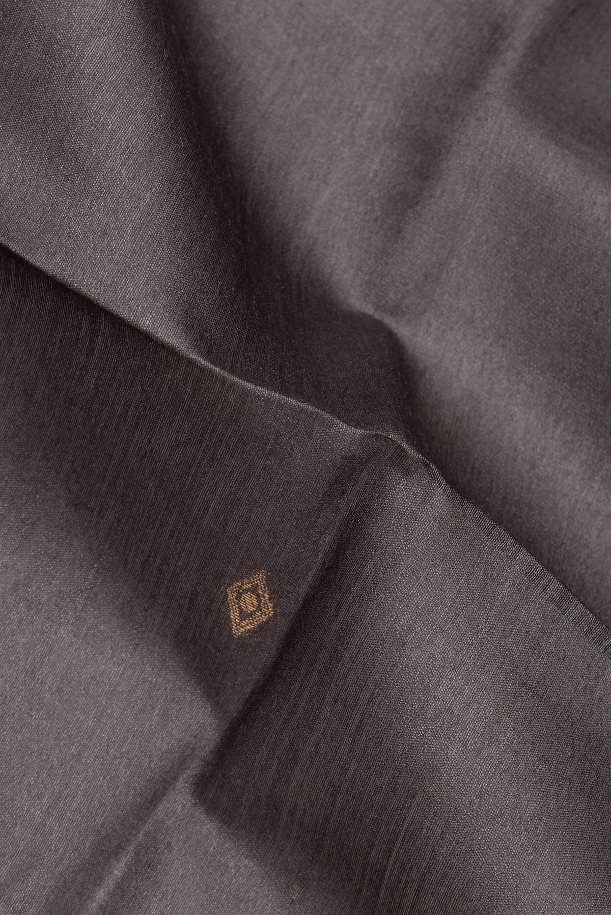 Close up of Grey Tussar Saree with Zari Butta on the body and Ikat Border.  displaying folds