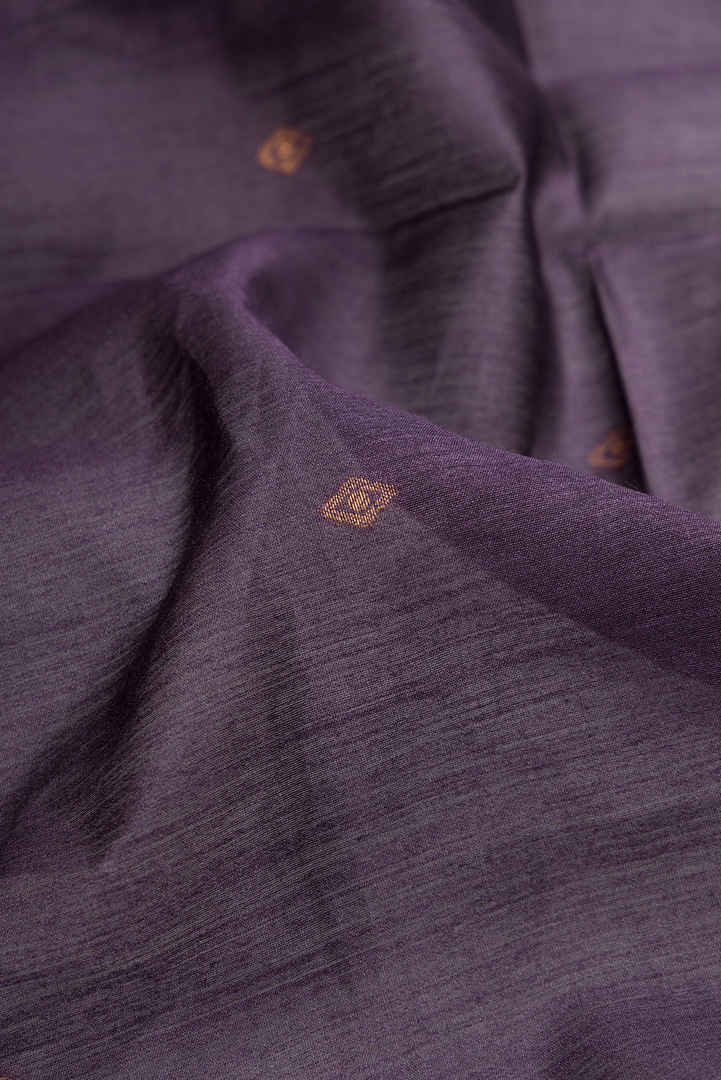 Close up of Purple Tussar Silk Saree with Zari Butta on the body and Printed Border.  displaying folds