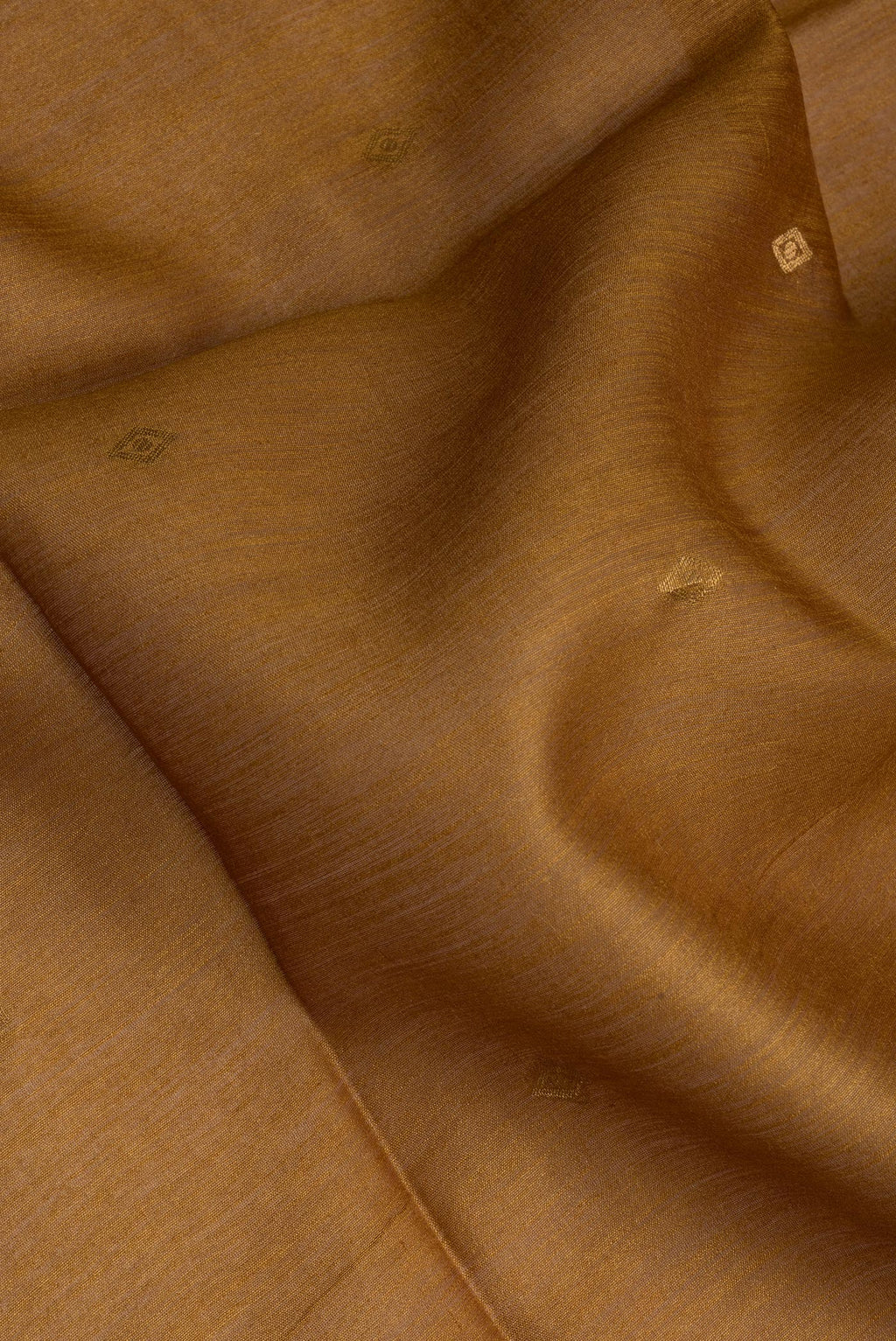 Close up of Mustard Tussar Silk Saree with Thread Butta on the body and Ikat Border.  displaying folds