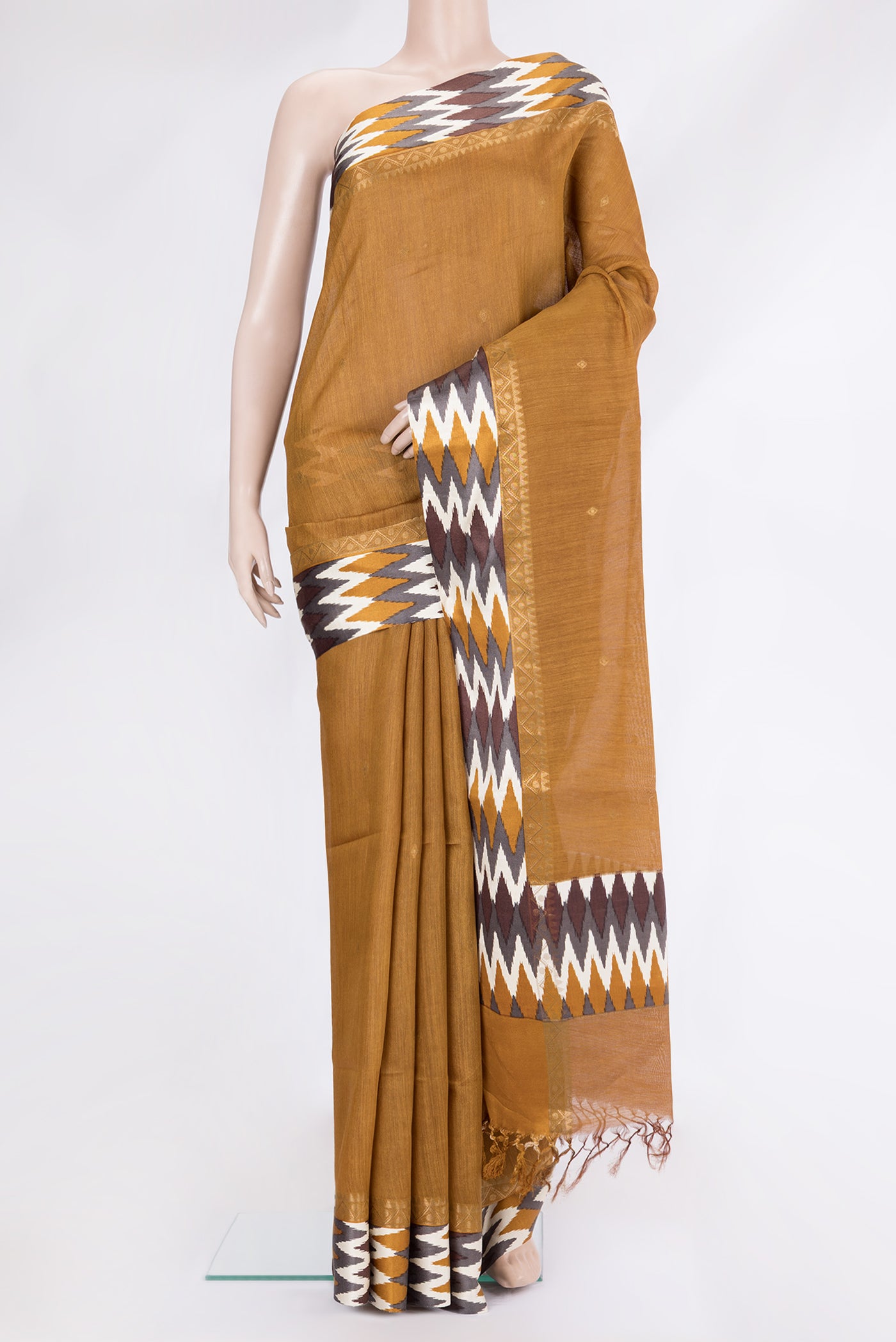 Mustard Tussar Silk Saree with Thread Butta on the body and Ikat Border.  displayed on a mannequin