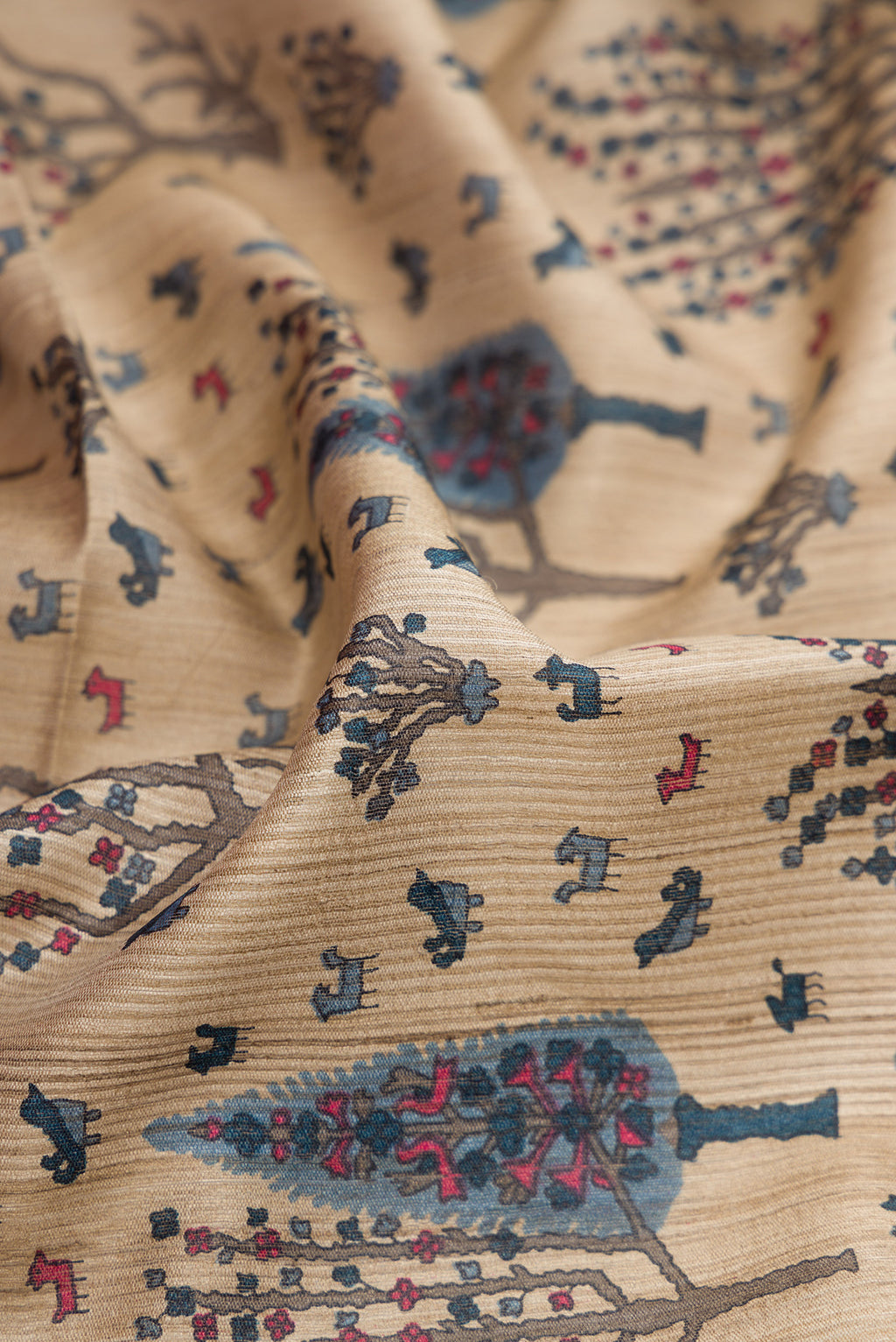 Close up of Beige Tussar Silk Saree with Printed design on the body and Zari Border.  displaying folds