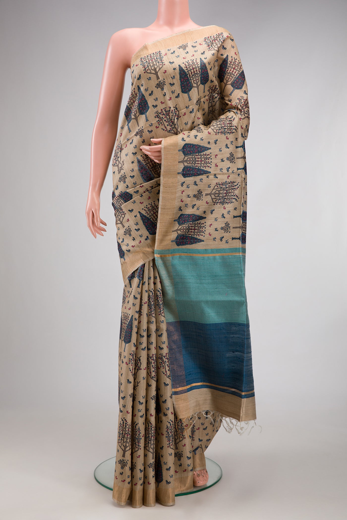Beige Tussar Silk Saree with Printed design on the body and Zari Border.  displayed on a mannequin
