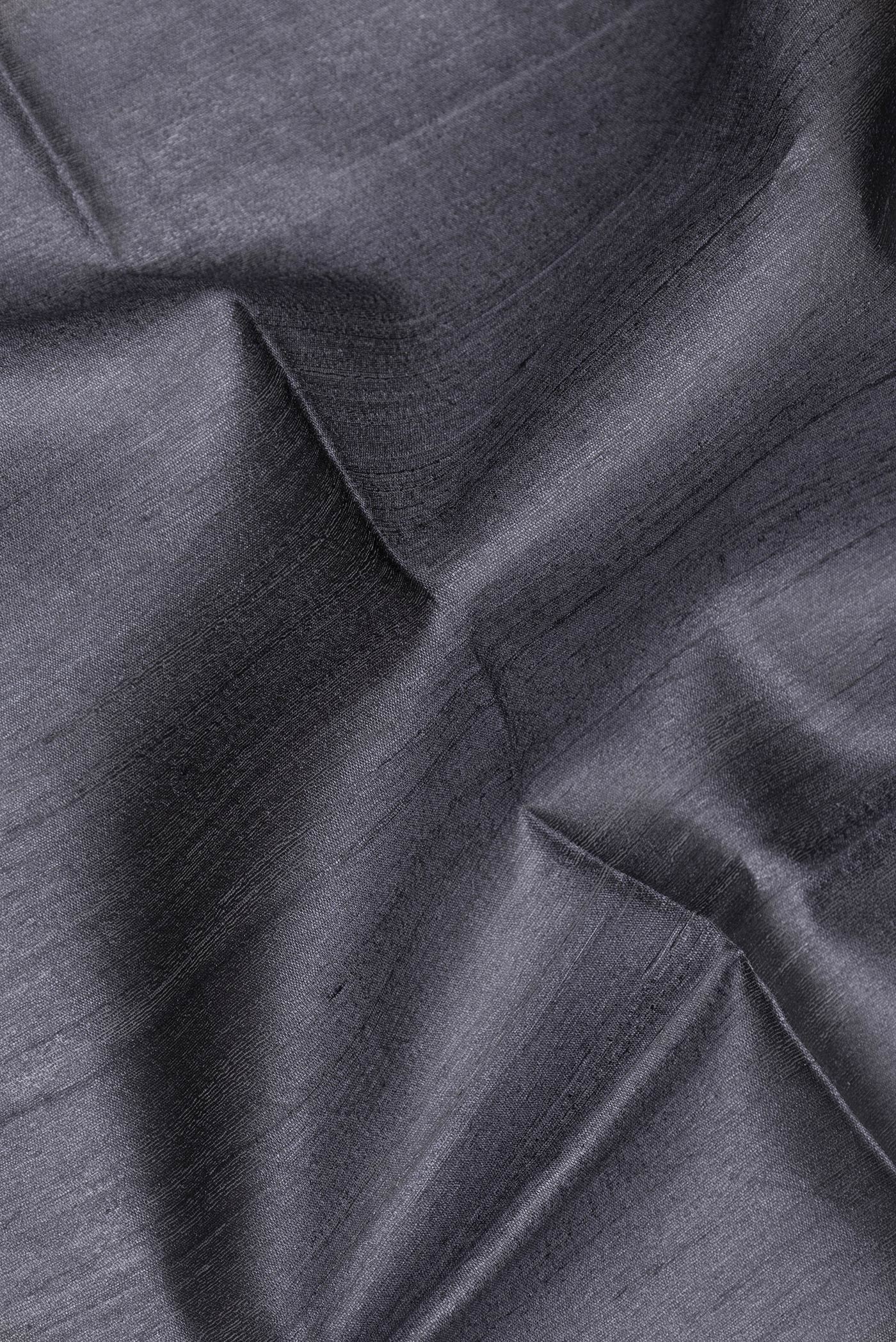 Close up of Grey Tussar Silk Saree with Plain Body and Zari Border.  displaying folds