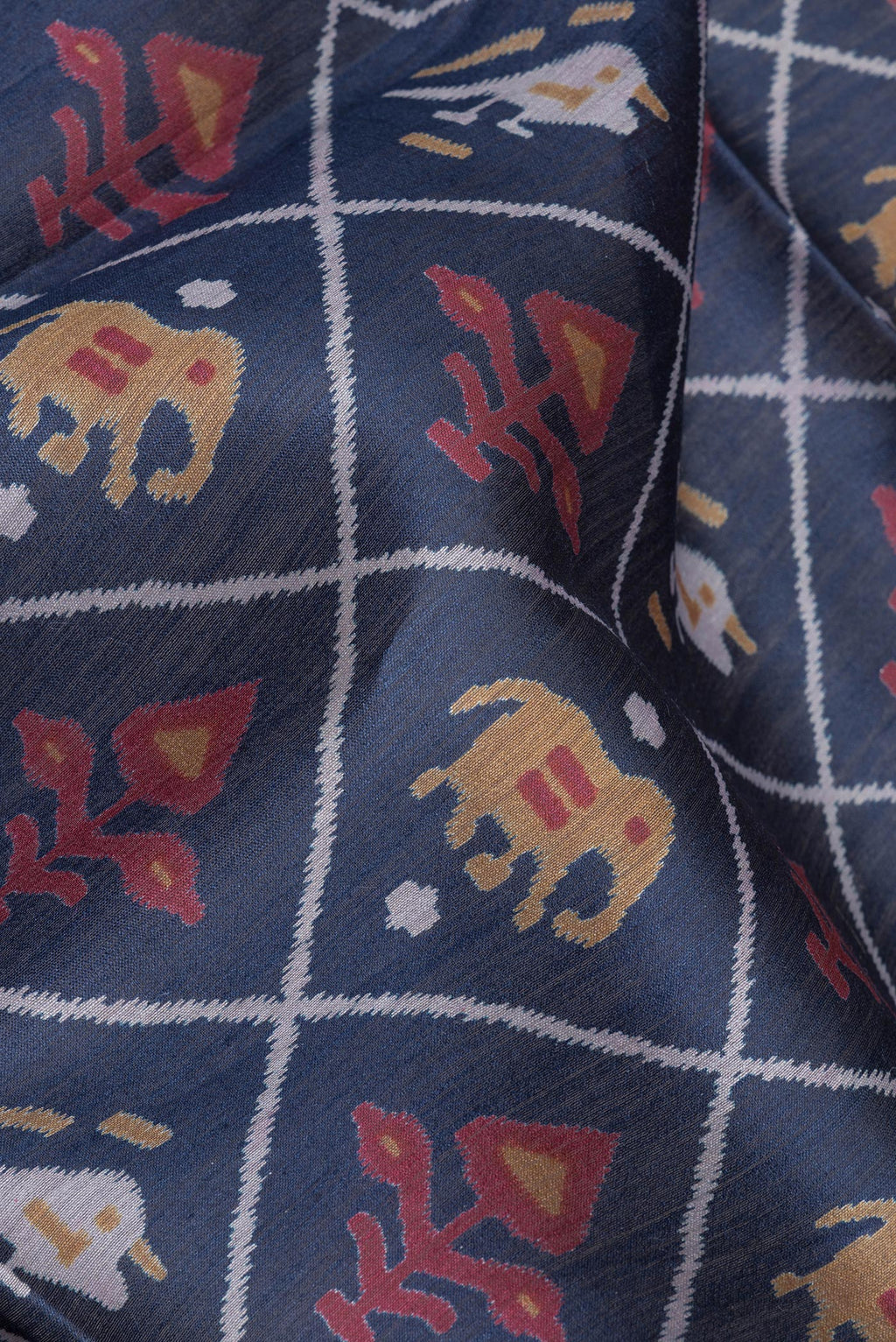 Close up of Blue Tussar Saree with Printed design on the body and Zari Border.  displaying folds
