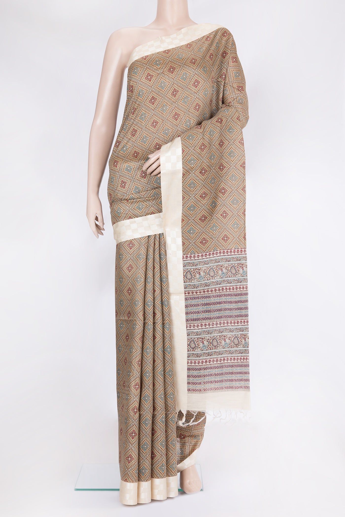Beige Tussar Silk Saree with Printed design on the body and Fancy Border.  displayed on a mannequin