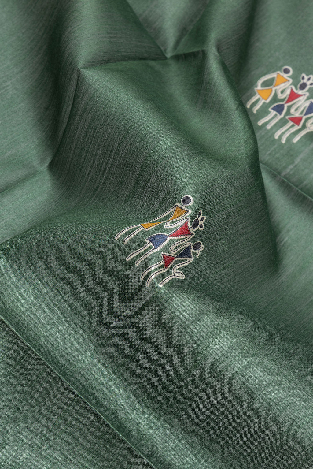 Close up of Green Tussar Silk Saree with Printed design on the body and Temple Border.  displaying folds