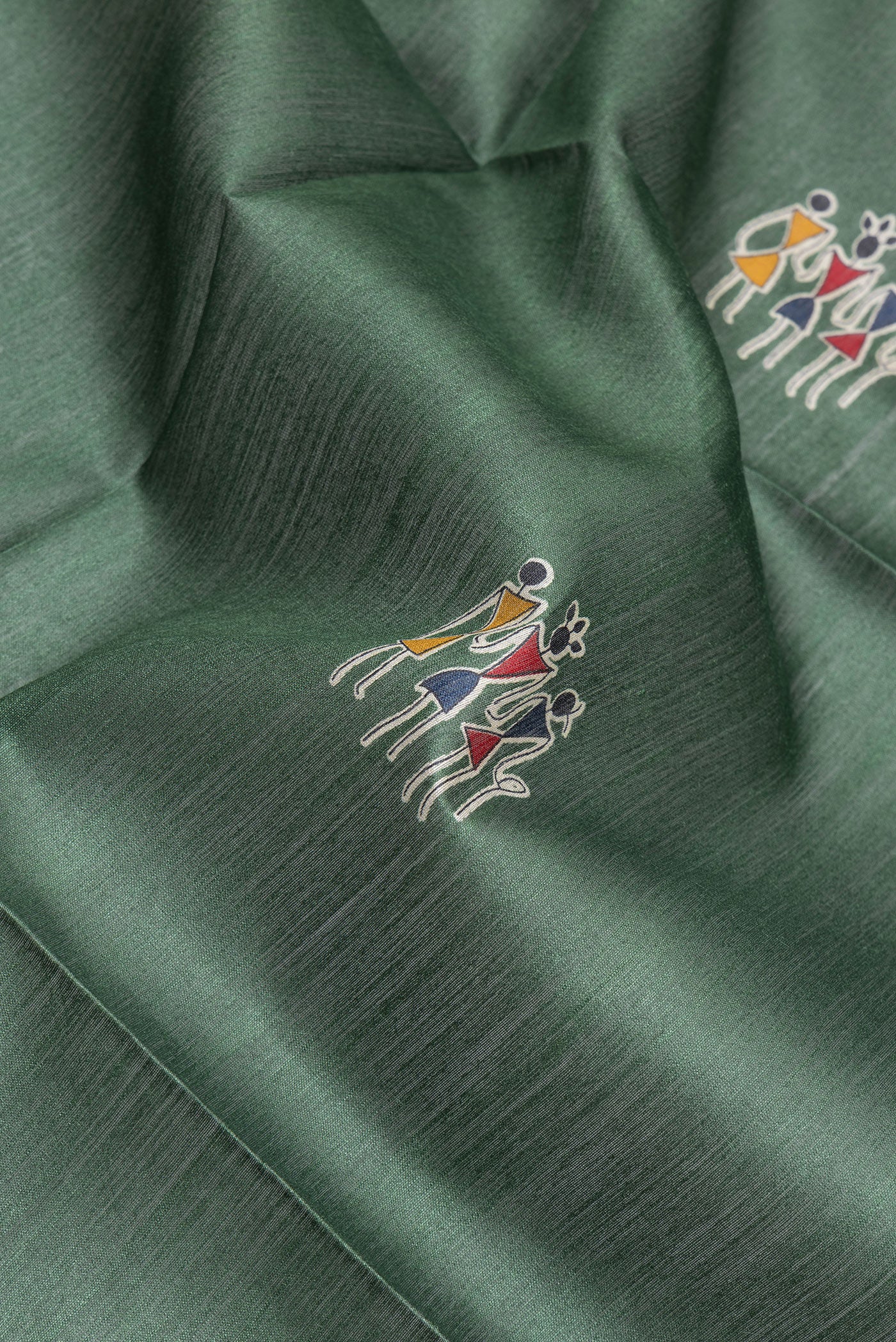 Close up of Green Tussar Silk Saree with Printed design on the body and Temple Border.  displaying folds
