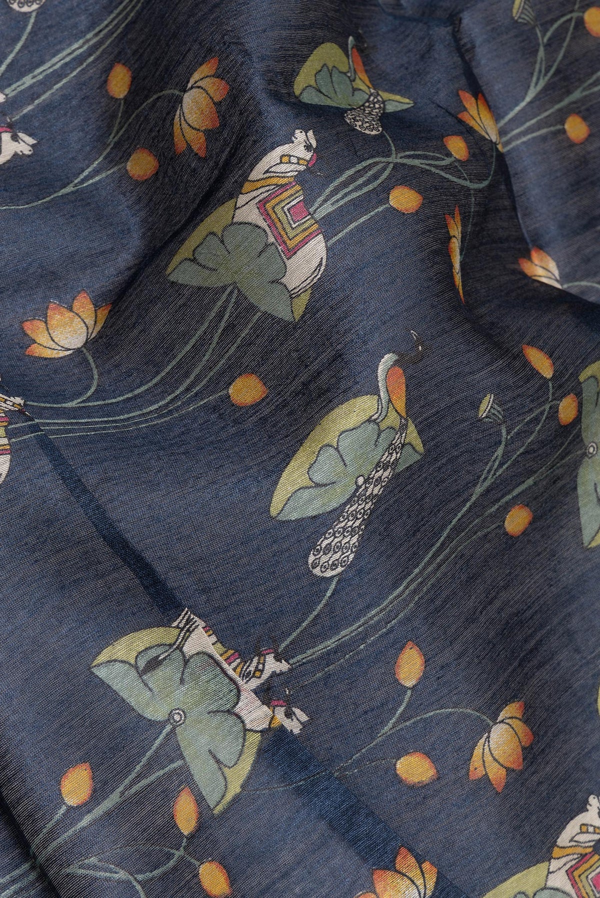 Close up of Navy Blue Tussar Saree with Printed design on the body and Zari Border.  displaying folds