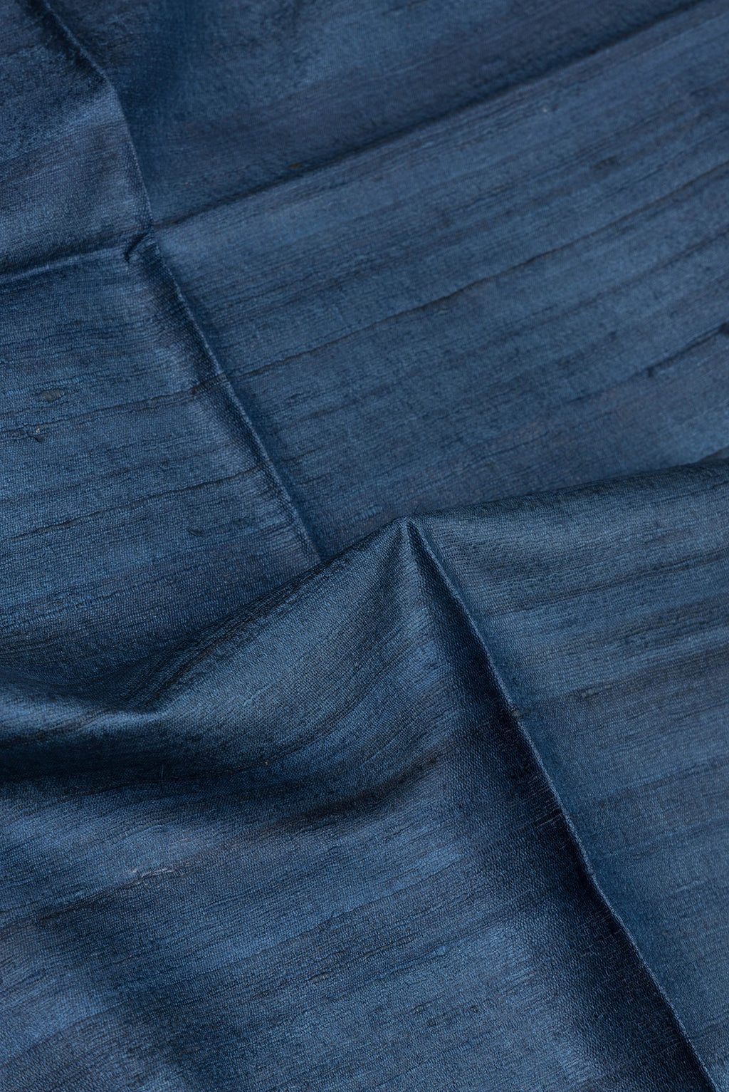 Close up of Blue Tussar Silk Saree with Plain Body and Fancy Border.  displaying folds