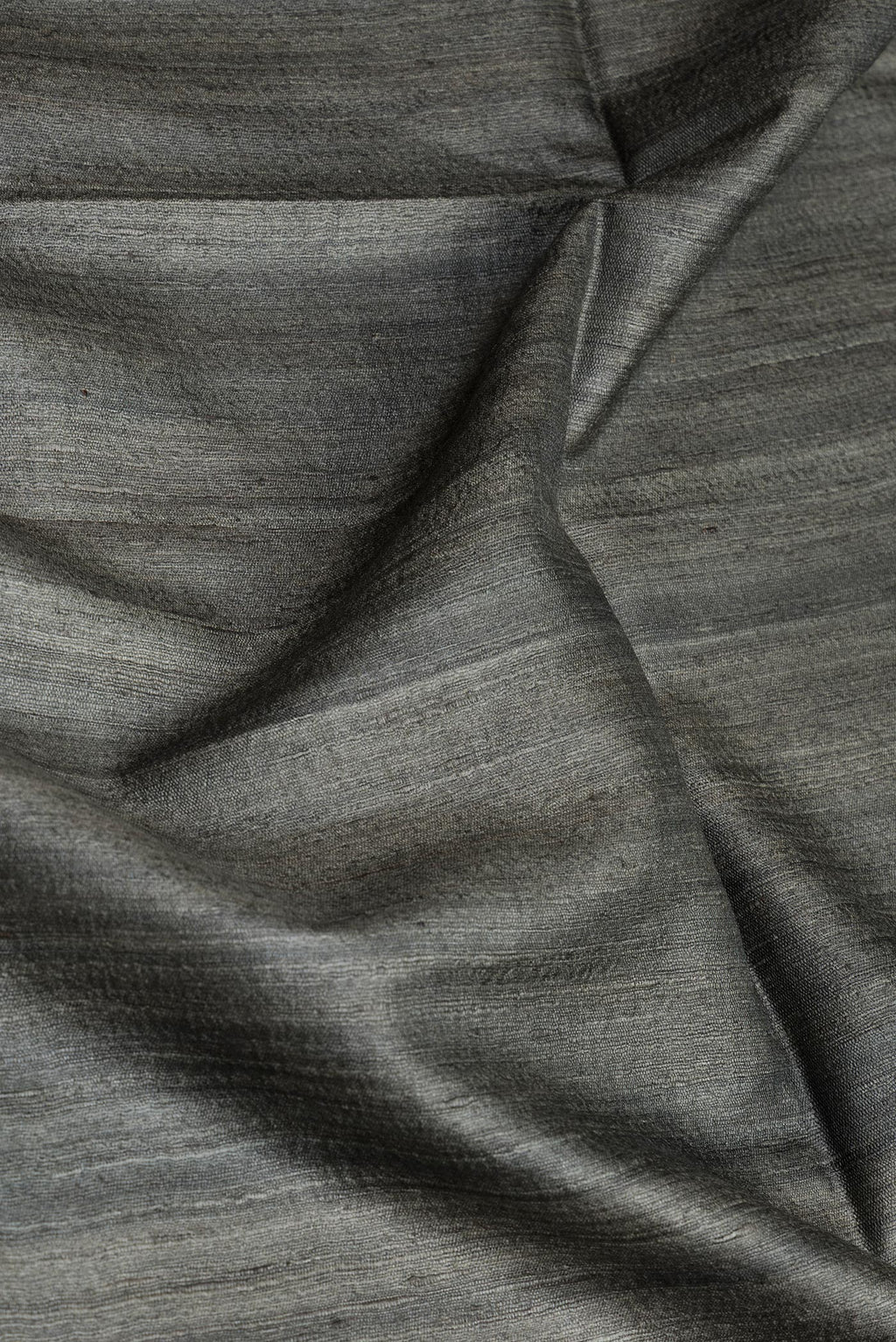Close up of Bottle Green Dual Tone Tussar Silk Saree with Plain Body and Plain Border.  displaying folds