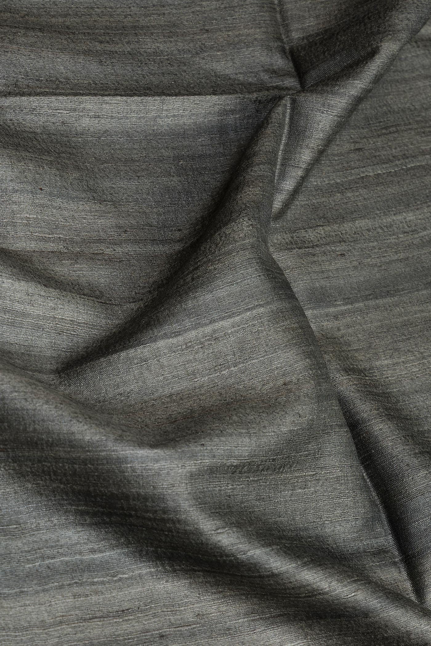 Close up of Bottle Green Dual Tone Tussar Silk Saree with Plain Body and Plain Border.  displaying folds