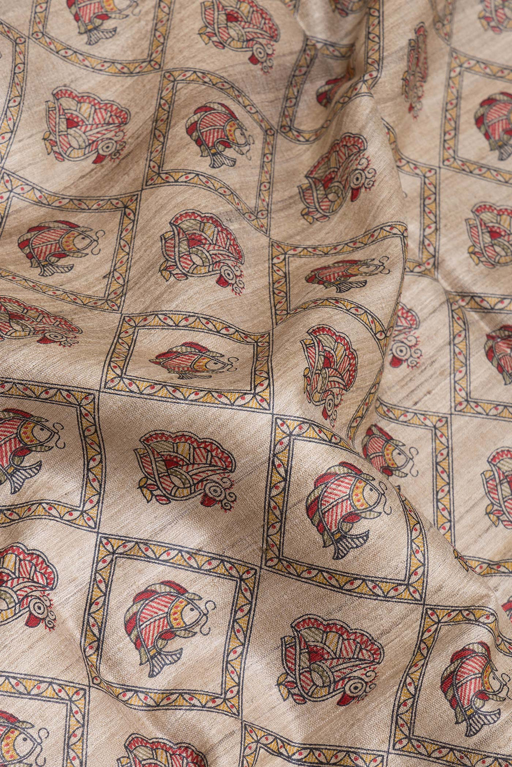 Close up of Beige Tussar Silk Saree with Printed design on the body and Fancy Border.  displaying folds