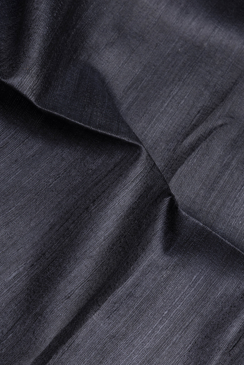 Close up of Black Tussar Silk Saree with Plain Body and Fancy Border.  displaying folds