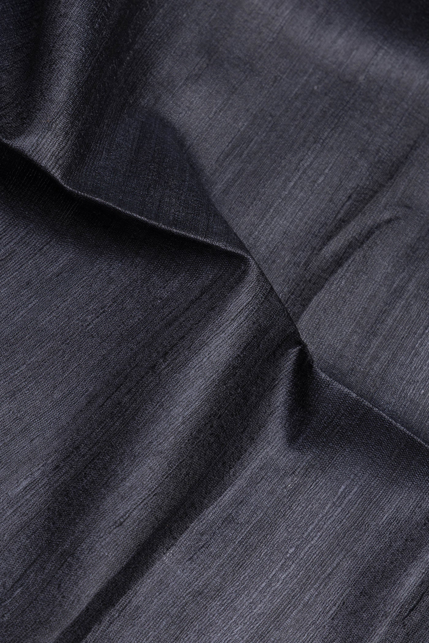 Close up of Black Tussar Silk Saree with Plain Body and Fancy Border.  displaying folds