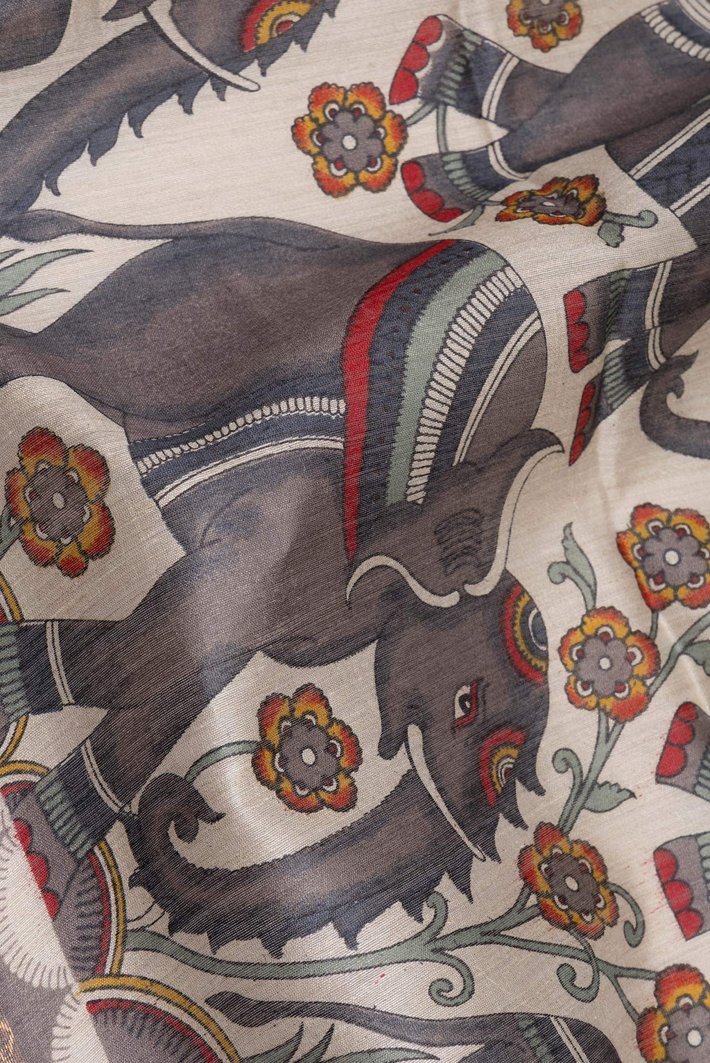 Close up of Grey Tussar Saree with Printed design on the body and Zari Border.  displaying folds