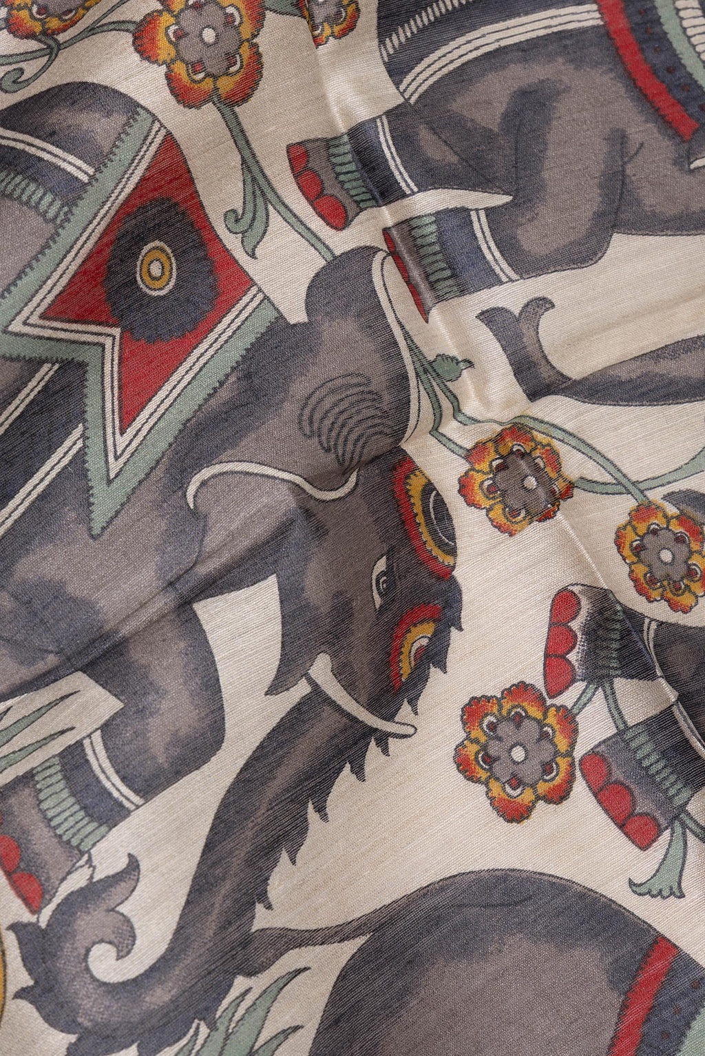 Close up of Beige Tussar Saree with Printed design on the body and Zari Border.  displaying folds