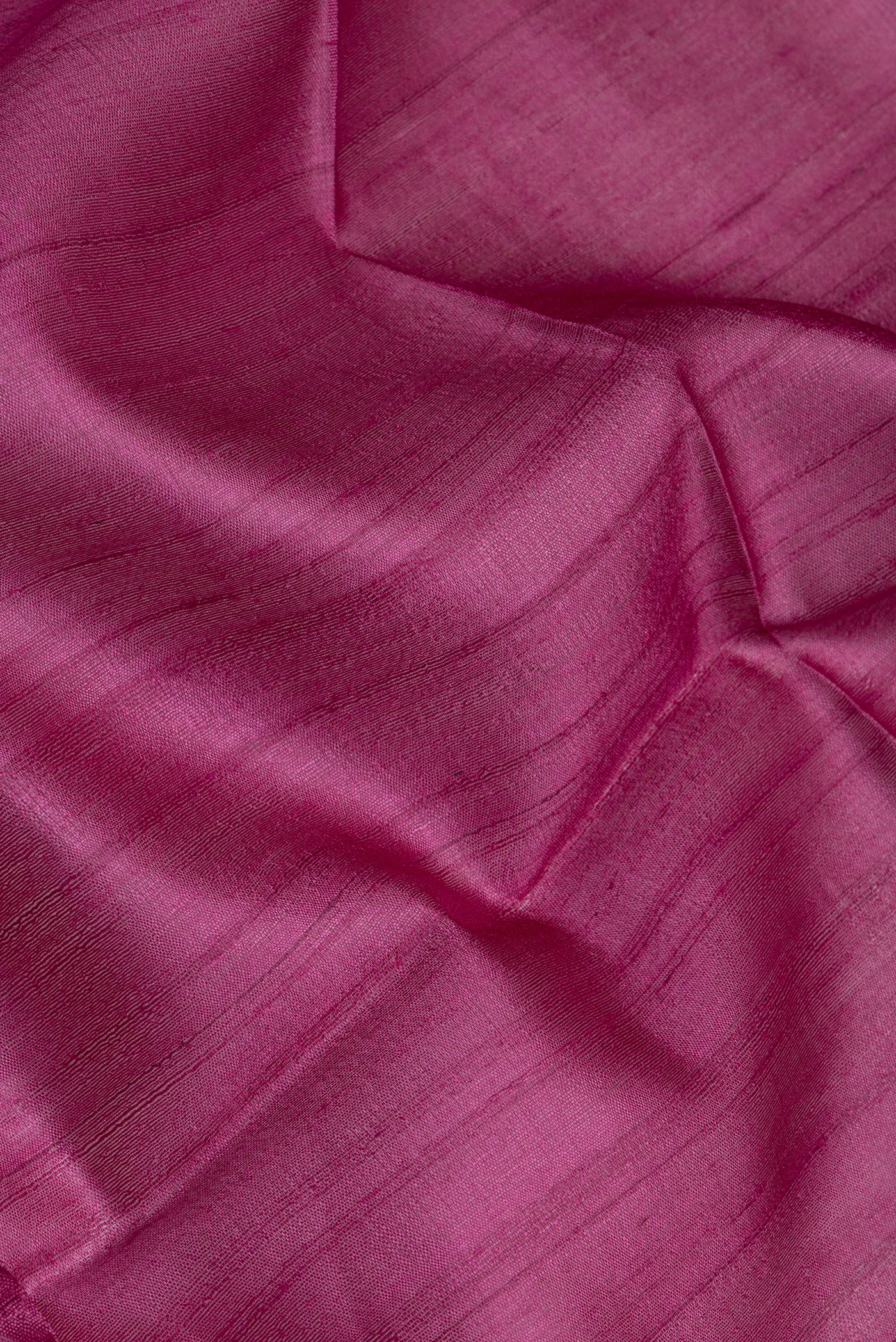 Close up of Pink Tussar Silk Saree with Thread Butta on the body and Zari Border.  displaying folds