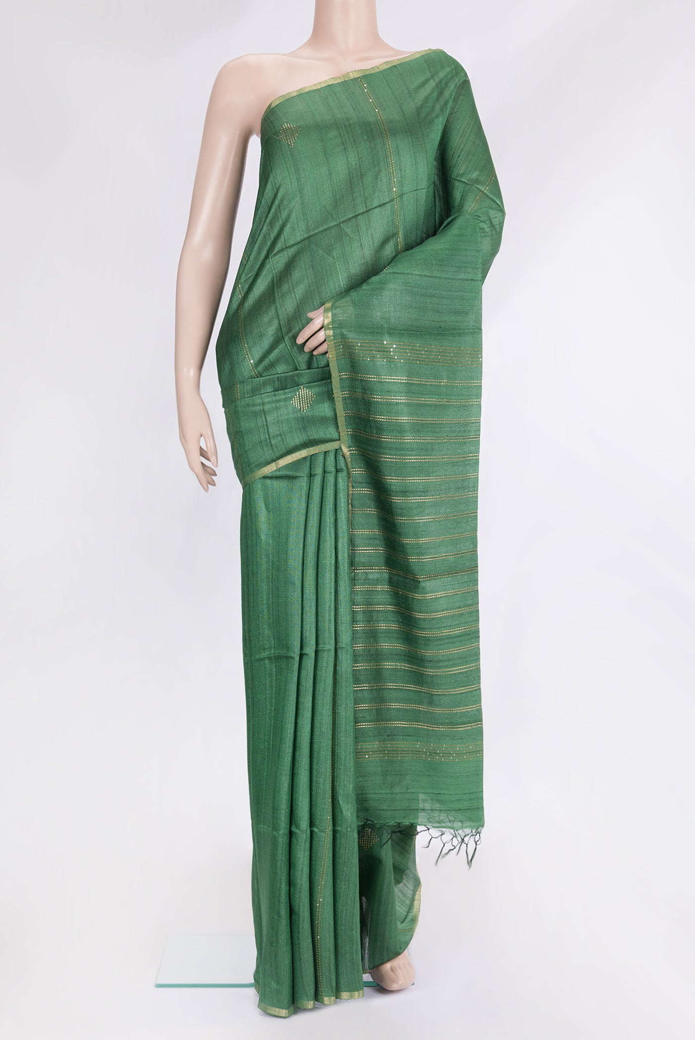 Green Tussar Silk Saree with Embroidery on the body and Zari Border.  displayed on a mannequin