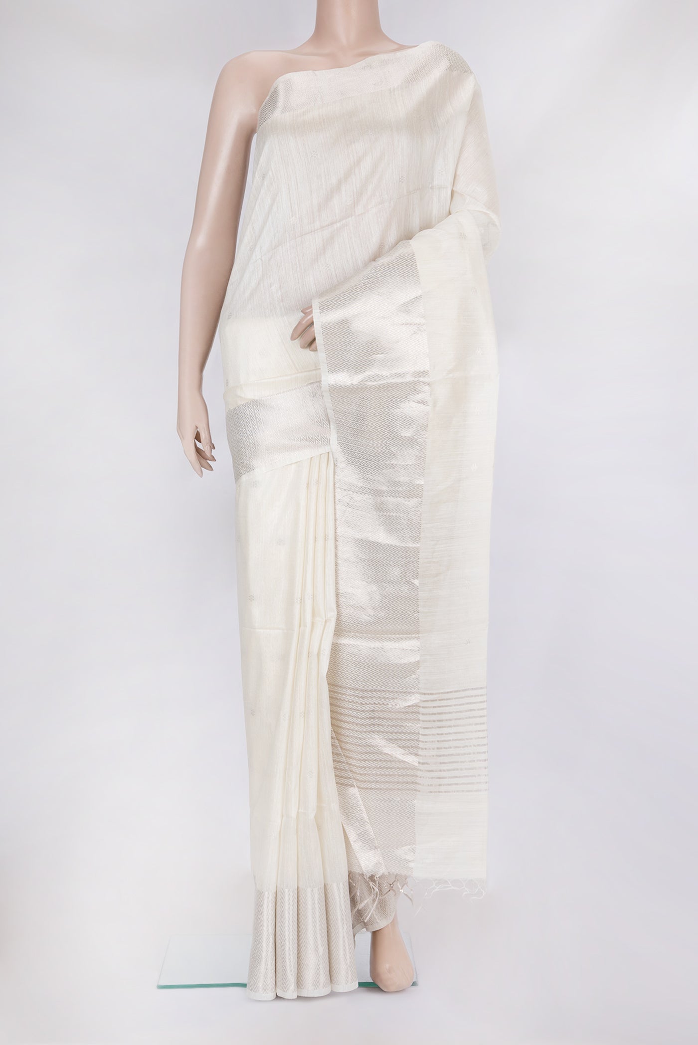 White Tussar Silk Saree with Zari Butta on the body and Zari Border.  displayed on a mannequin