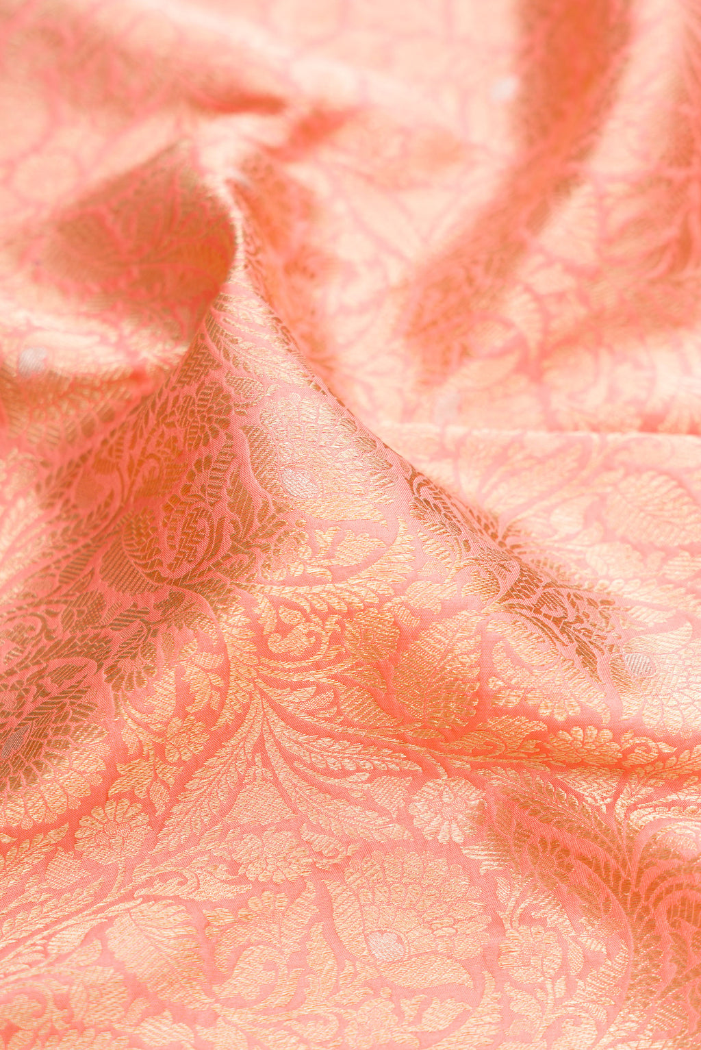 Close up of Peach Banarasi Silk Saree with Zari Brocade on the body and Zari Border.  displaying folds