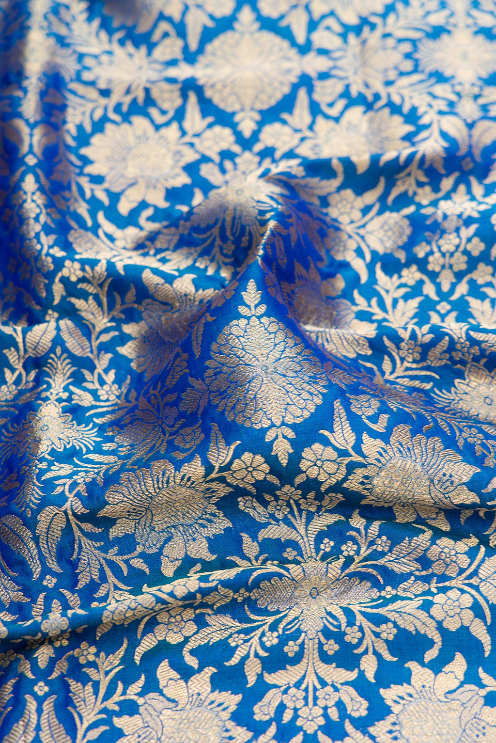Close up of Peacock Blue Banarasi Silk Saree with Zari Brocade on the body and Zari Border.  displaying folds