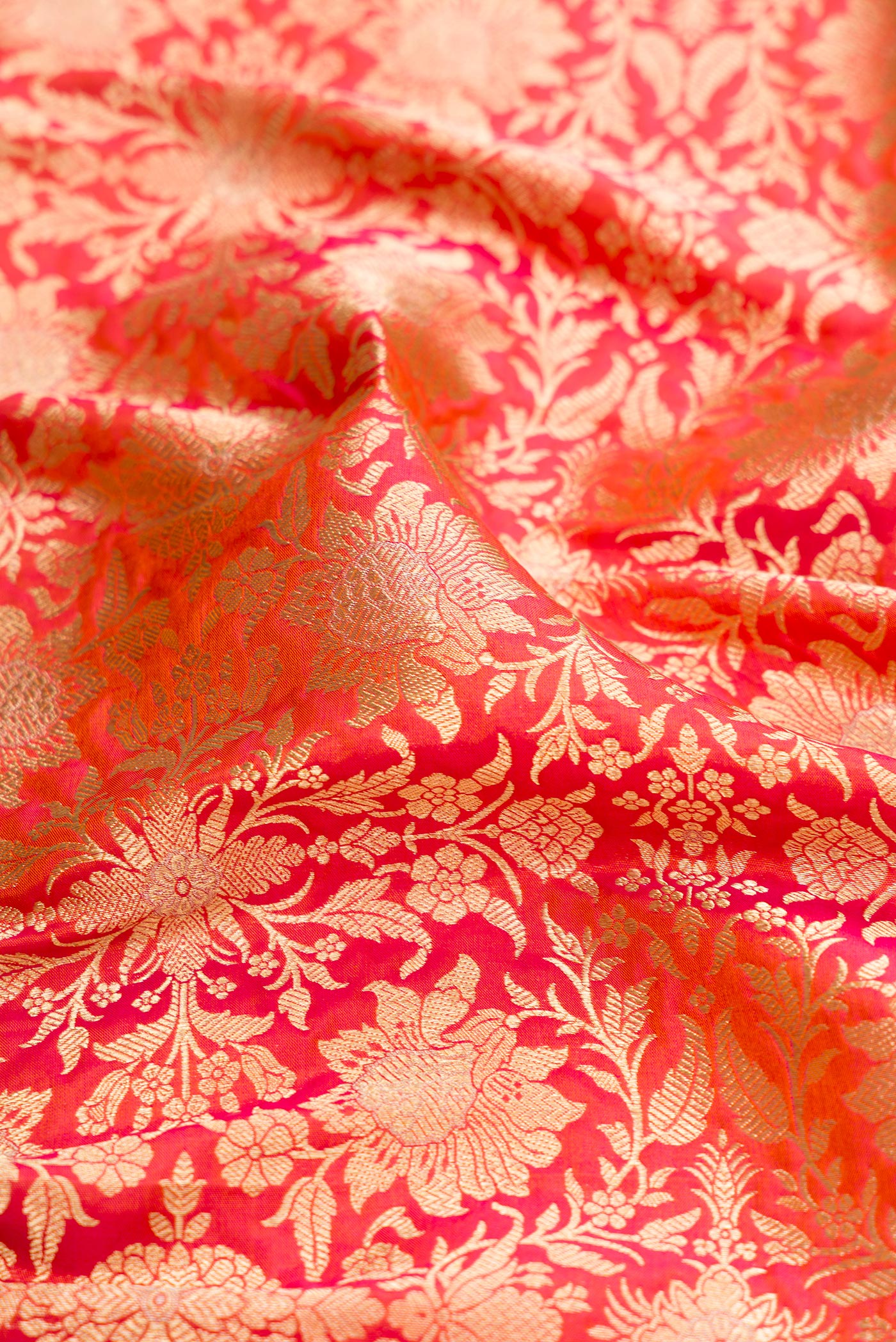 Close up of Orange Banarasi Silk Saree with Zari Brocade on the body and Zari Border.  displaying folds