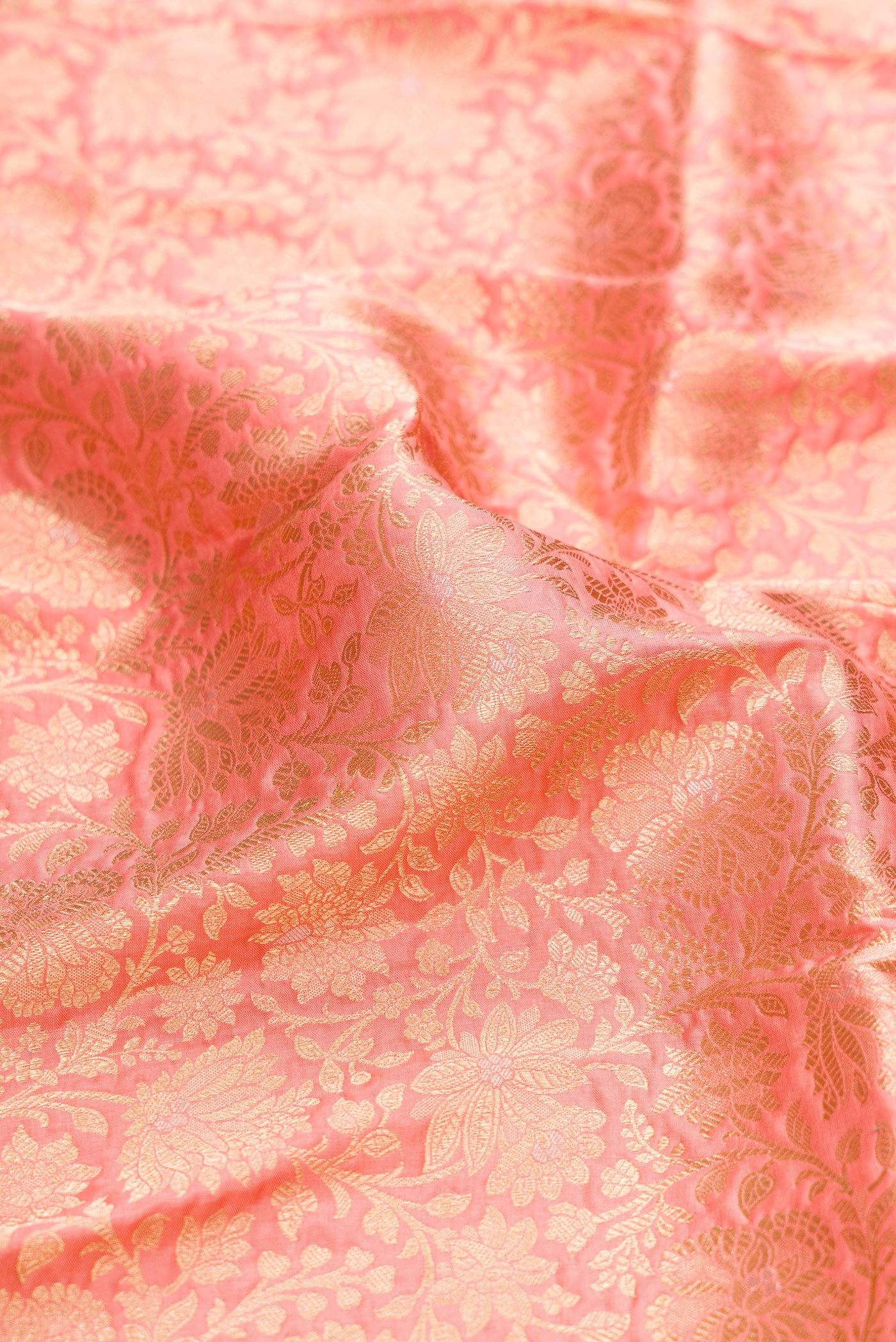 Close up of Golden Peach Banarasi Silk Saree with Zari Brocade on the body and Zari Border.  displaying folds