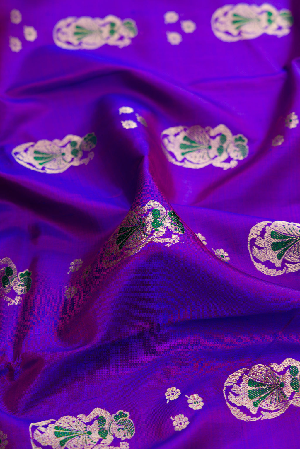 Close up of Purple Dual Tone Baluchari Silk Saree with Zari And Thread Butta on the body and Zari Border.  displaying folds