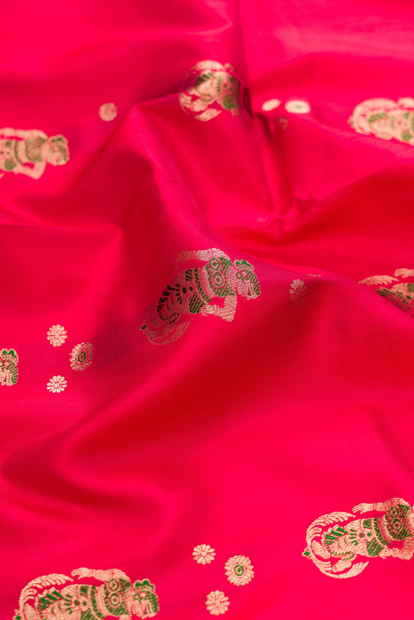 Close up of Dark Pink Baluchari Silk Saree with Zari And Thread Butta on the body and Zari And Thread Border.  displaying folds