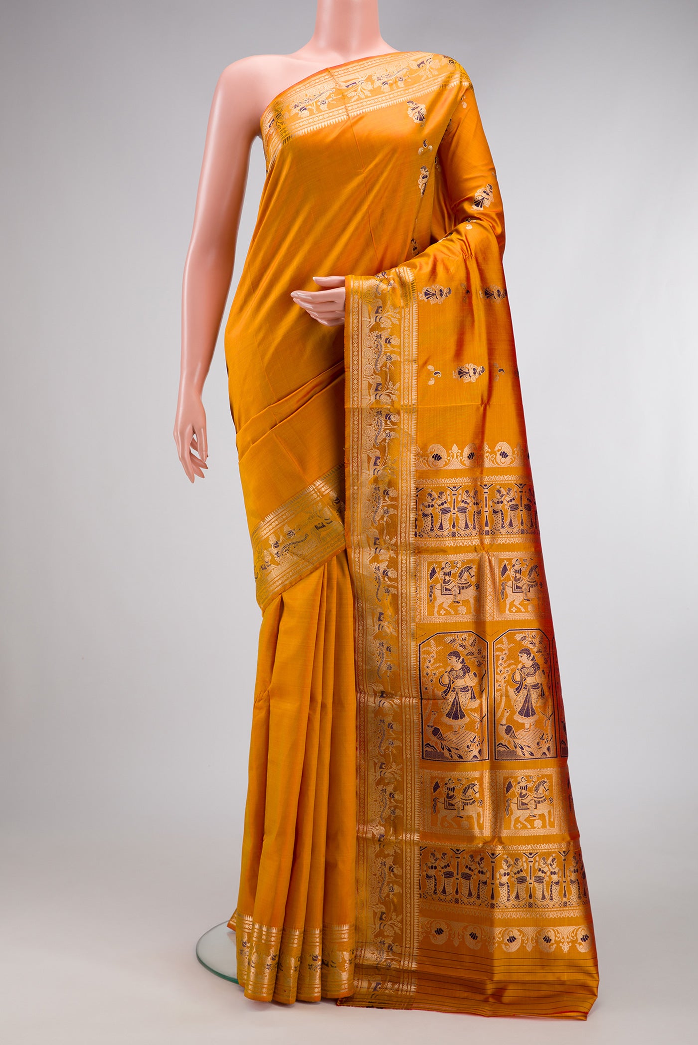 Mustard Baluchari Silk Saree with Zari And Thread Butta on the body and Zari Border.  displayed on a mannequin