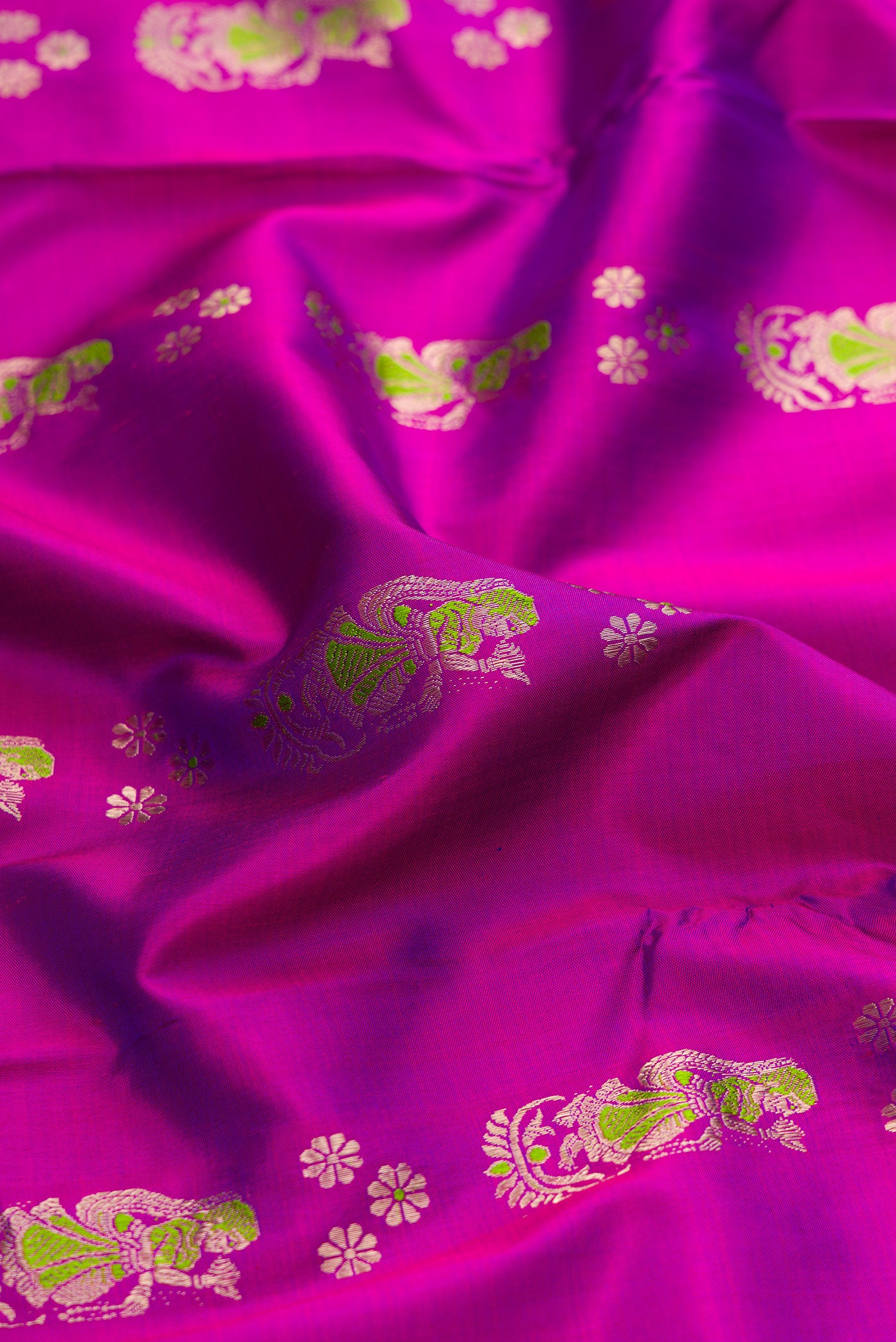 Close up of Purple Baluchari Silk Saree with Zari And Thread Butta on the body and Zari Border.  displaying folds