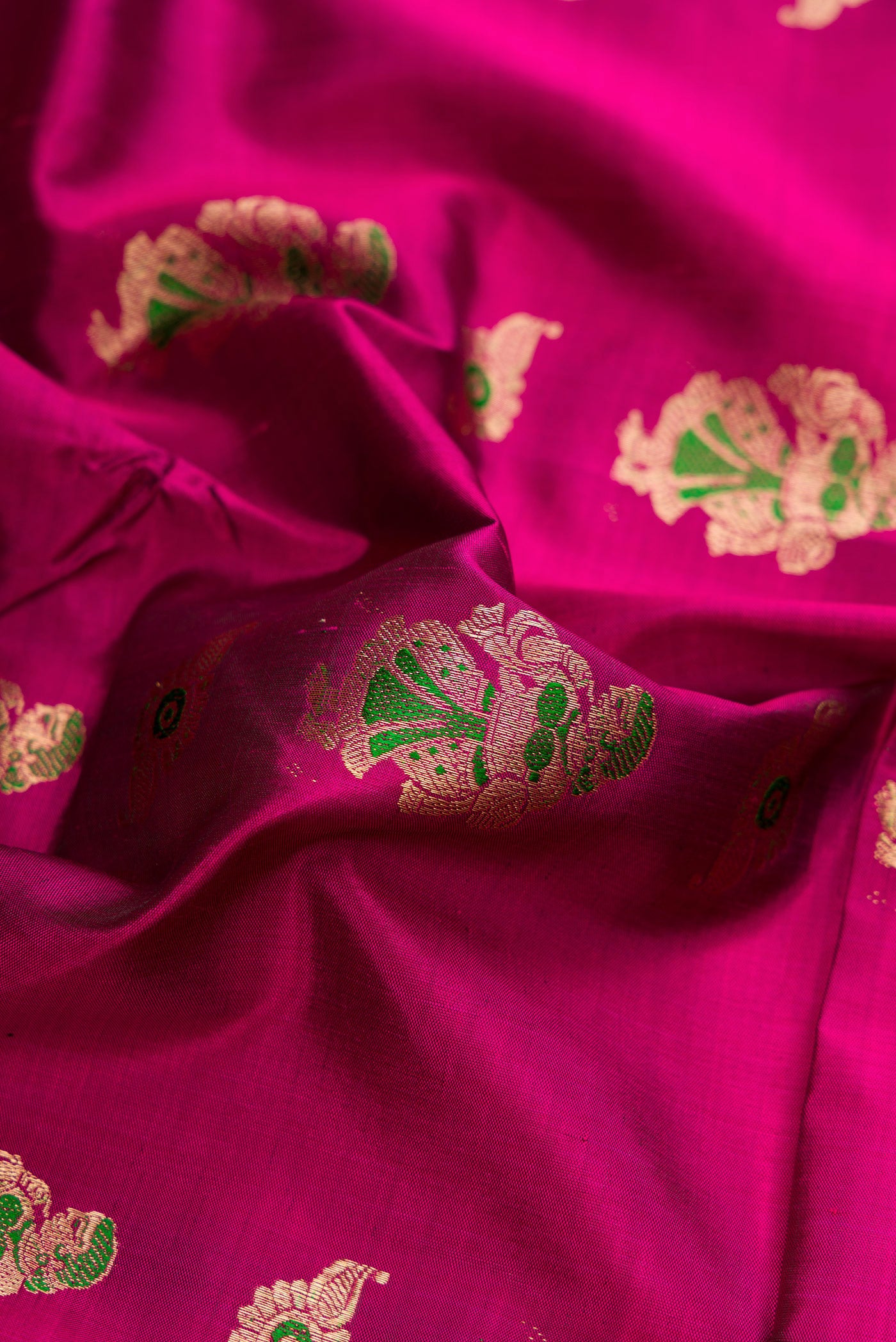 Close up of Magenta Baluchari Silk Saree with Zari And Thread Butta on the body and Zari Border.  displaying folds